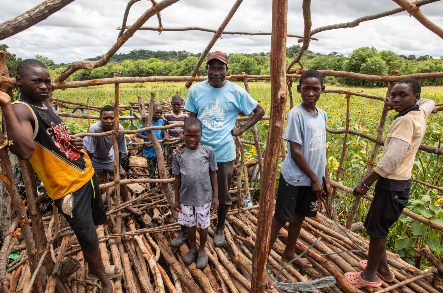 Sakurayi (in a blue T‑shirt) working on his goats’ kraal alongside Jeremiah (left) and his siblings