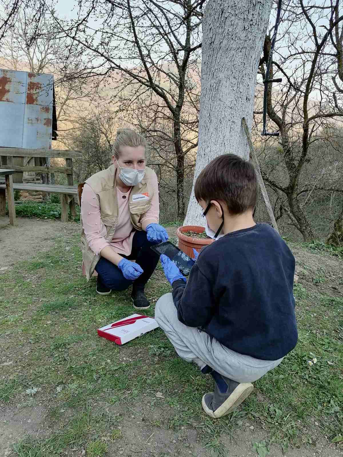 Edisa Ahmetspahic helps a boy, first time tablet-computer user configure the device