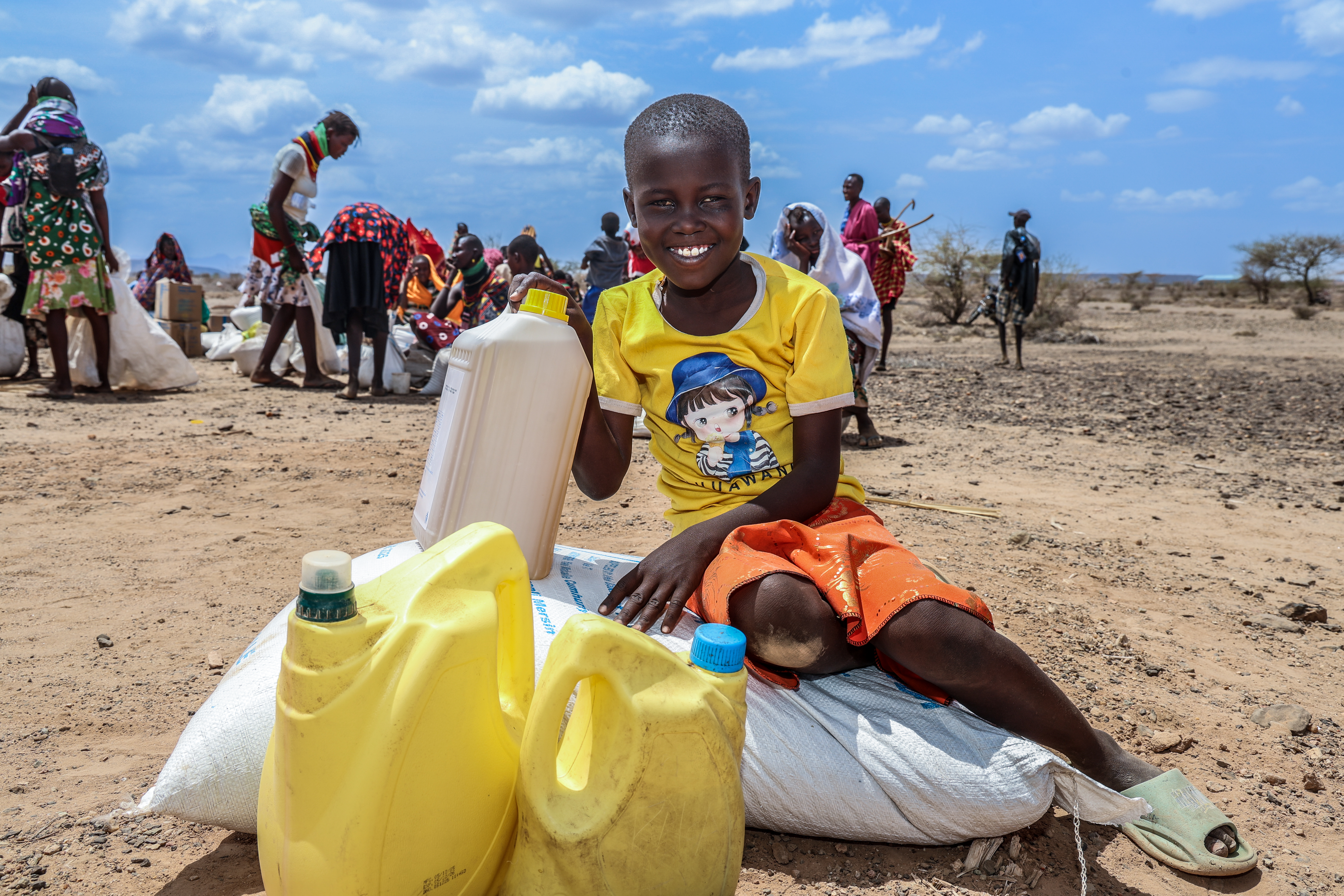 A joyous 8-year-old child from Nalemakais village, Turkana South, holds the family’s food supplies after a relief distribution. A powerful reminder that even in the midst of drought, hope can still shine through. ©World Vision Photo/Mirriam Kioko