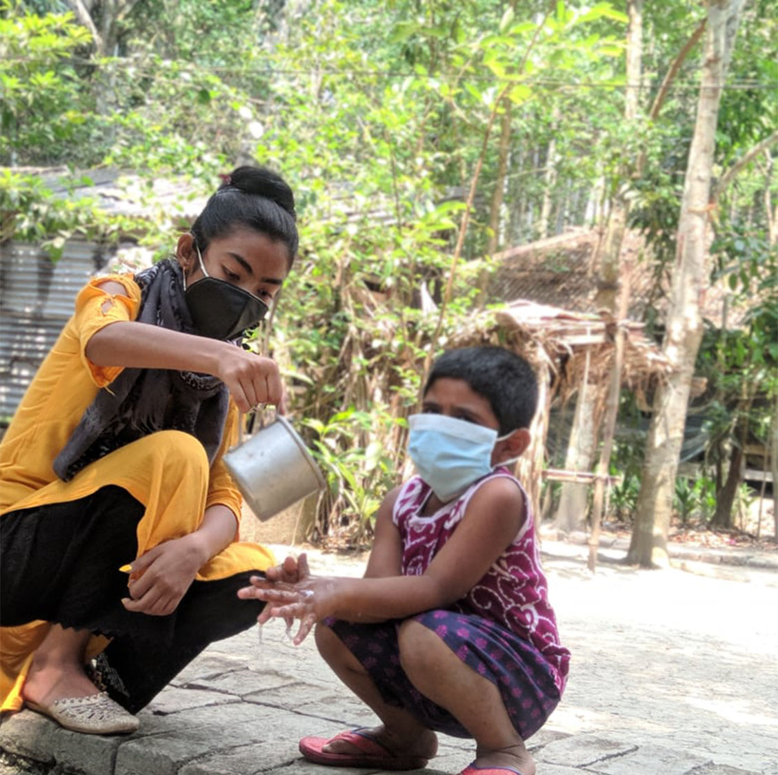 Farzana is helping community child to wash his hands properly