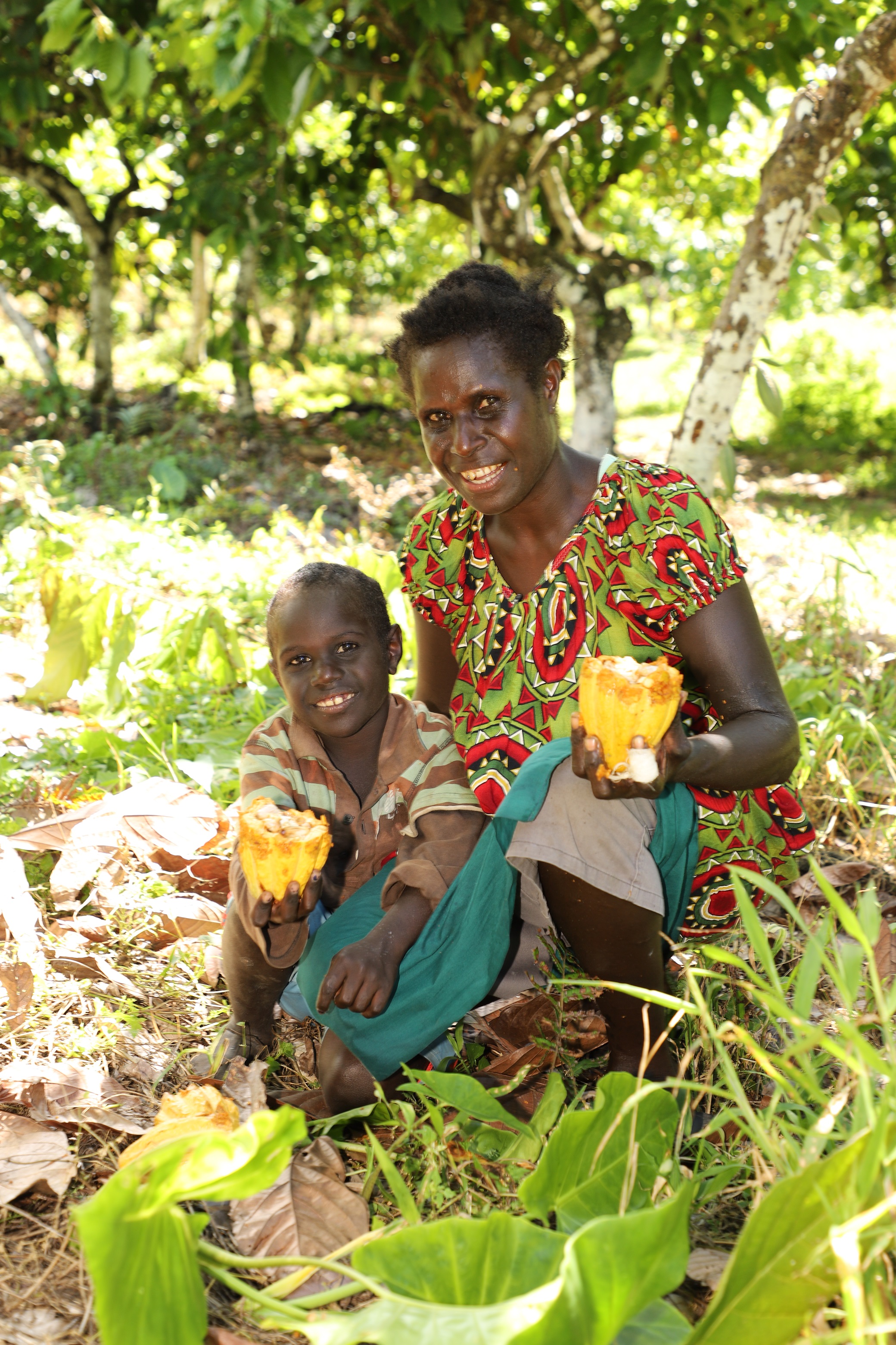 Francisca and John showing off a cocoa pod