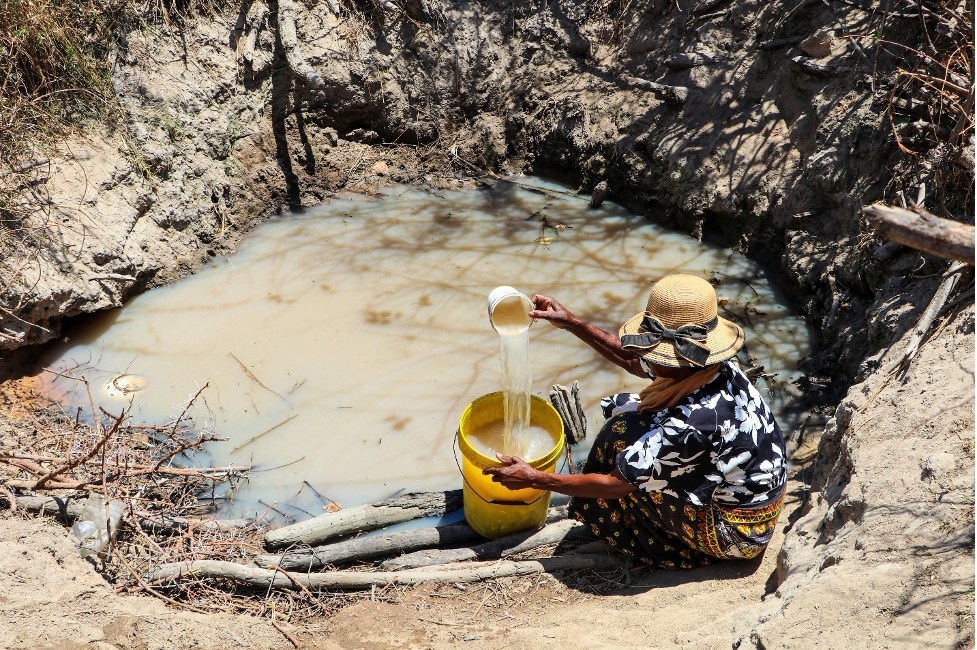 Dolika demonstrates how she used to fetch water from an unprotected source