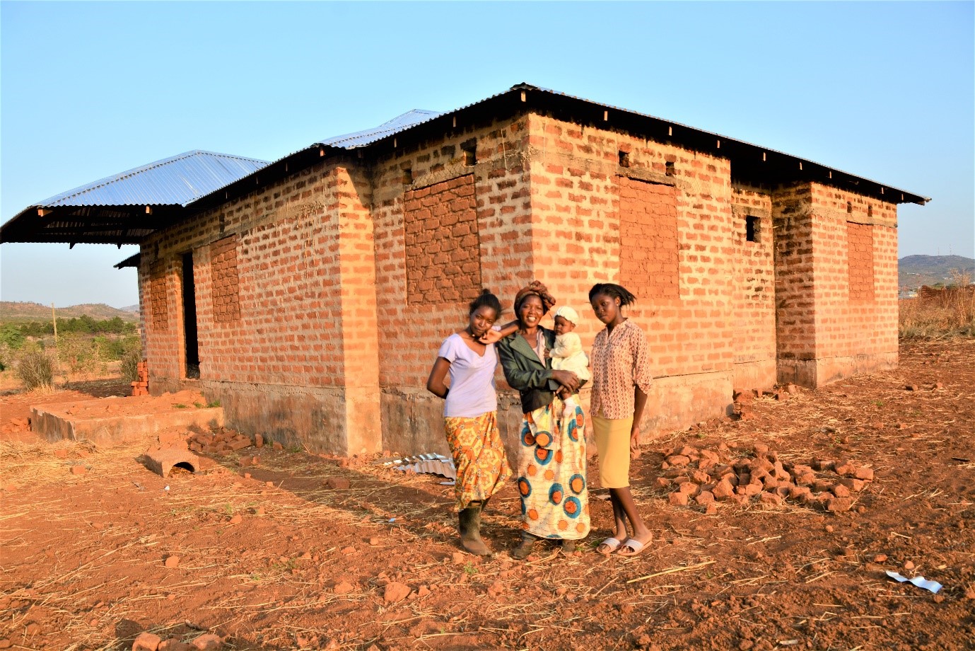 Grace and her children outside her house