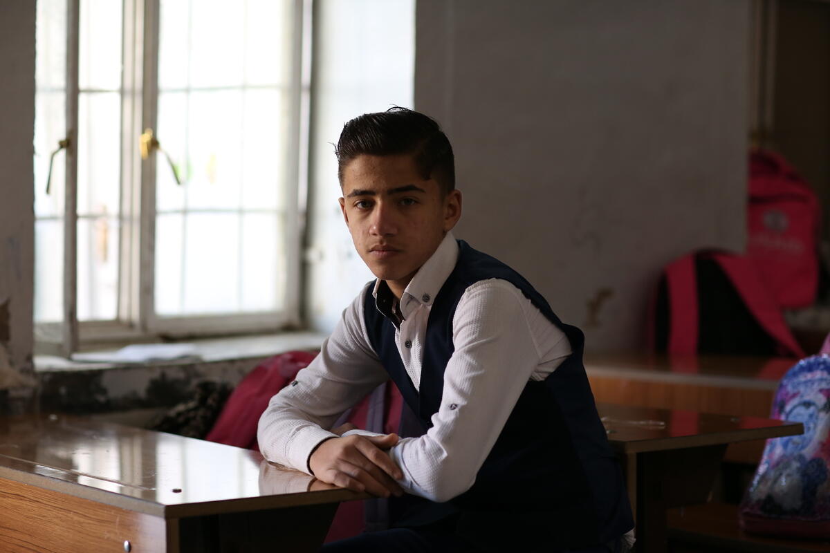 Hamza sits at a desk