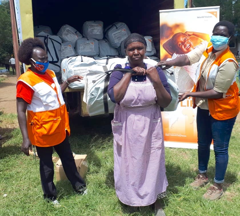 Ngendo receives Non Food Items (NFI) kits from World Vision staff at a camp for people affected by floods at Ndabibi in Nakuru County, Kenya. ©World Vision Photo.