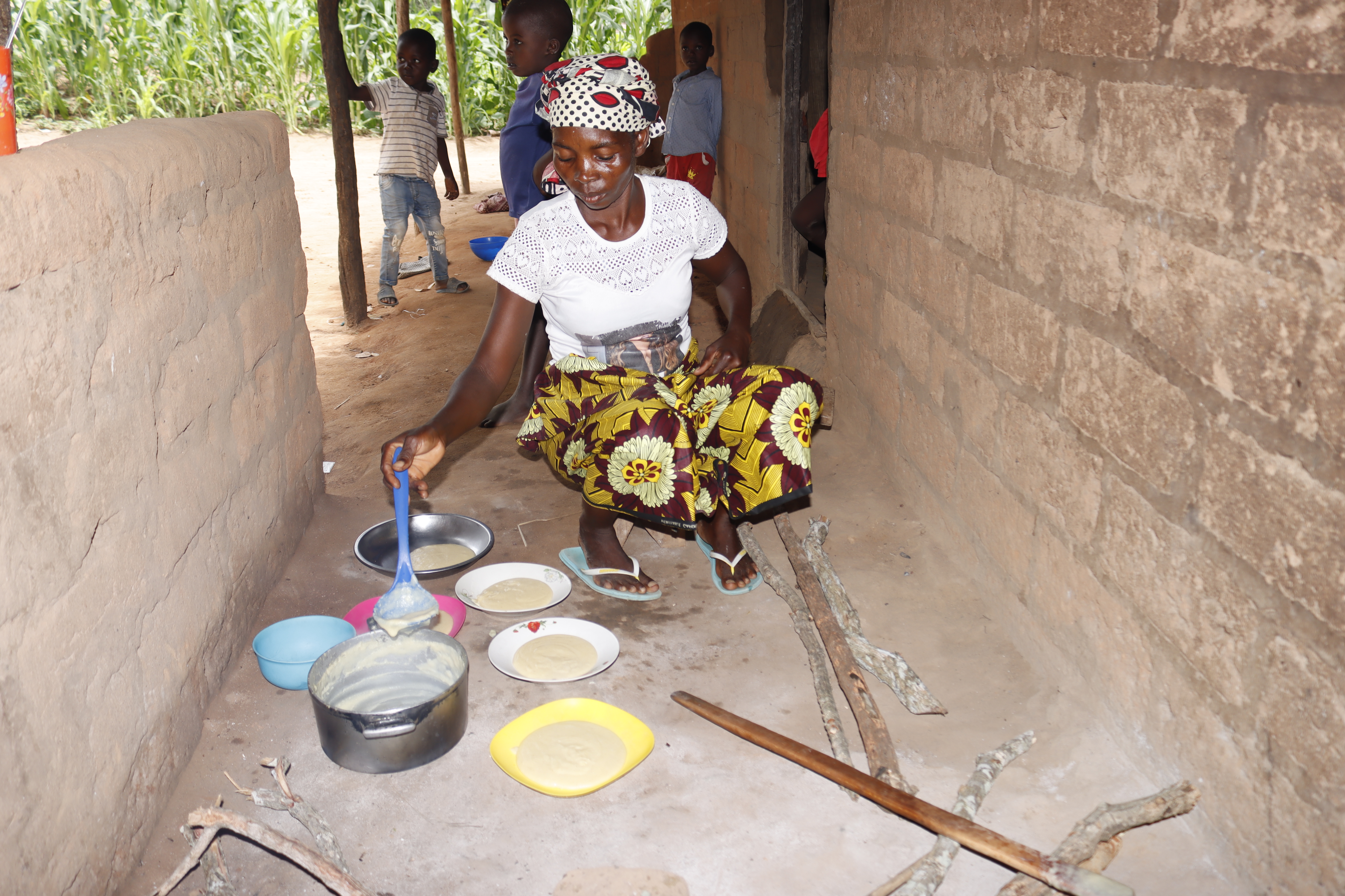 Filomena serves the porridge in small round plates 