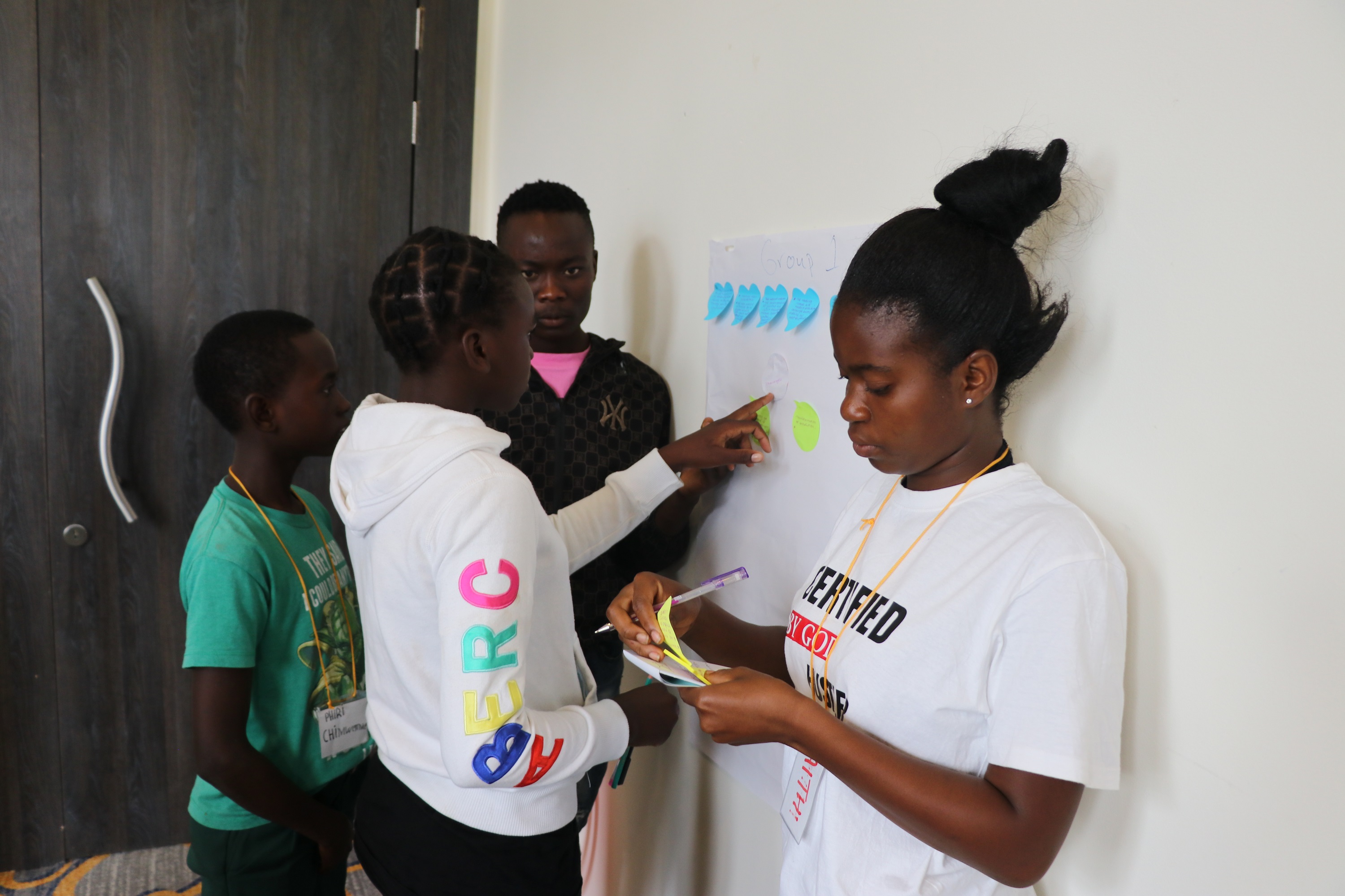 children sticking notes on the board