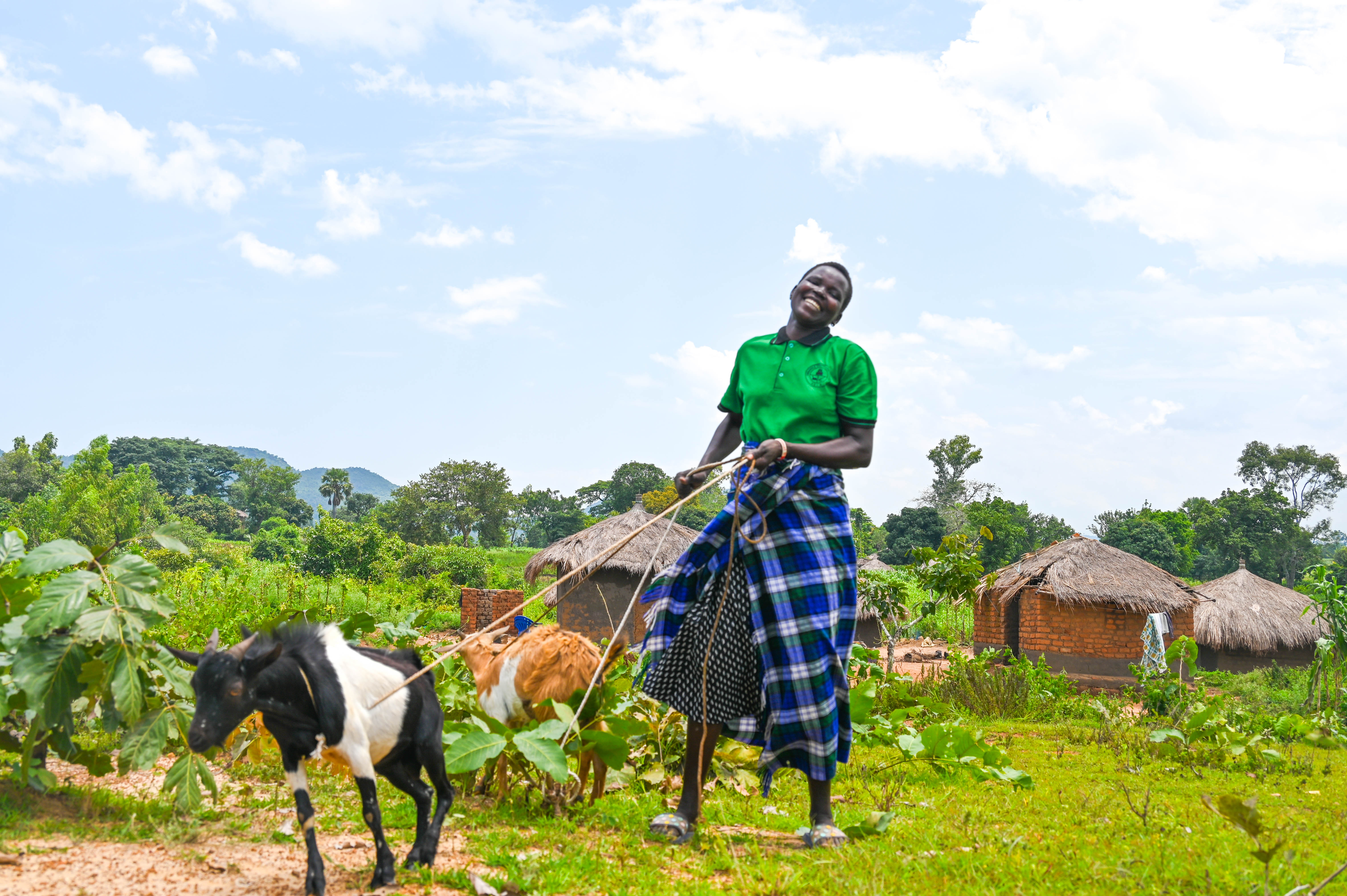 Stella attentively cares for the goat she acquired through the proceeds of her successful milling business.