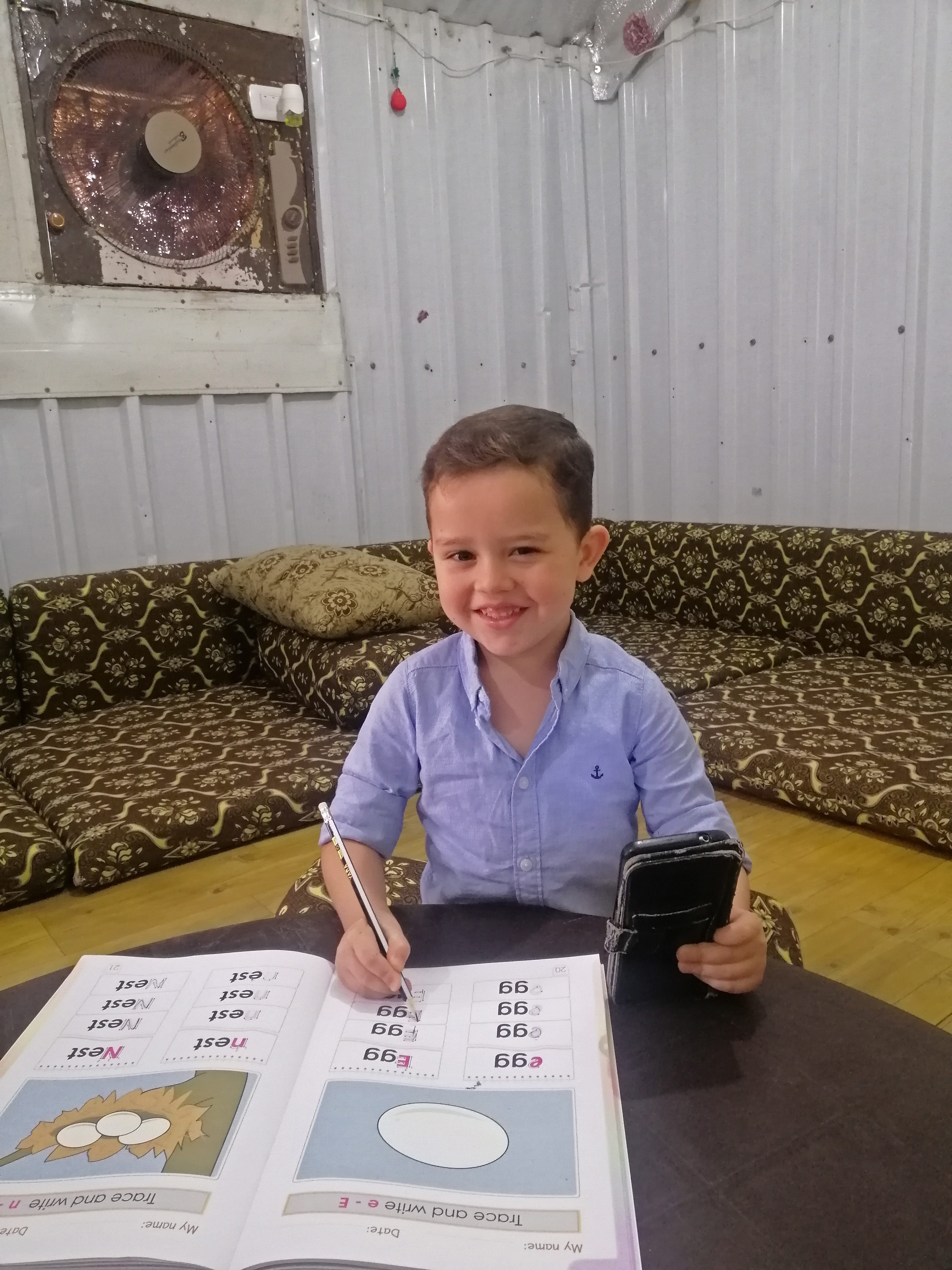 A portrait of Qutaibah, 5, while studying inside his home