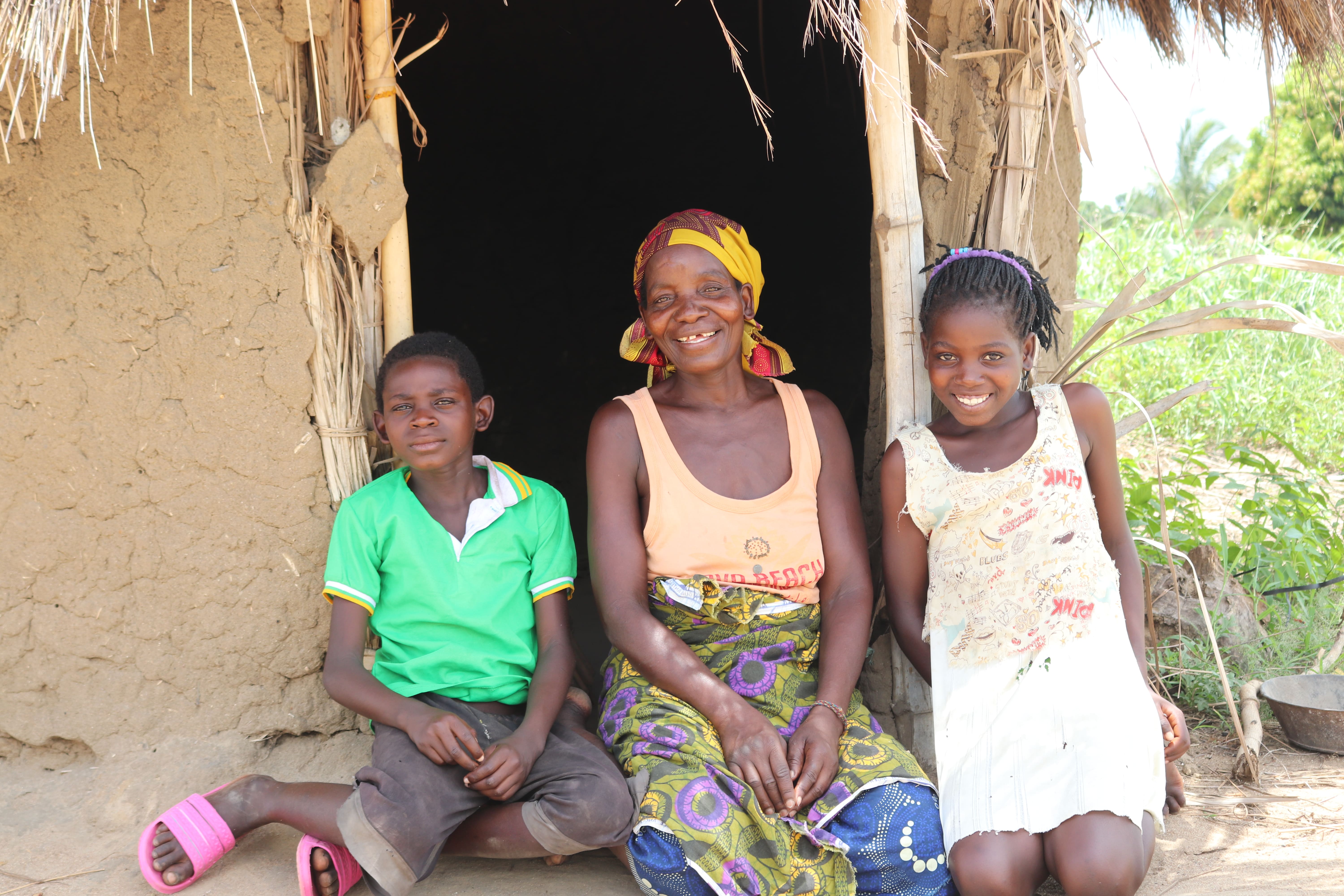 Laurinda, Jorge and their mother Julieta are sitting in front of their their small hut