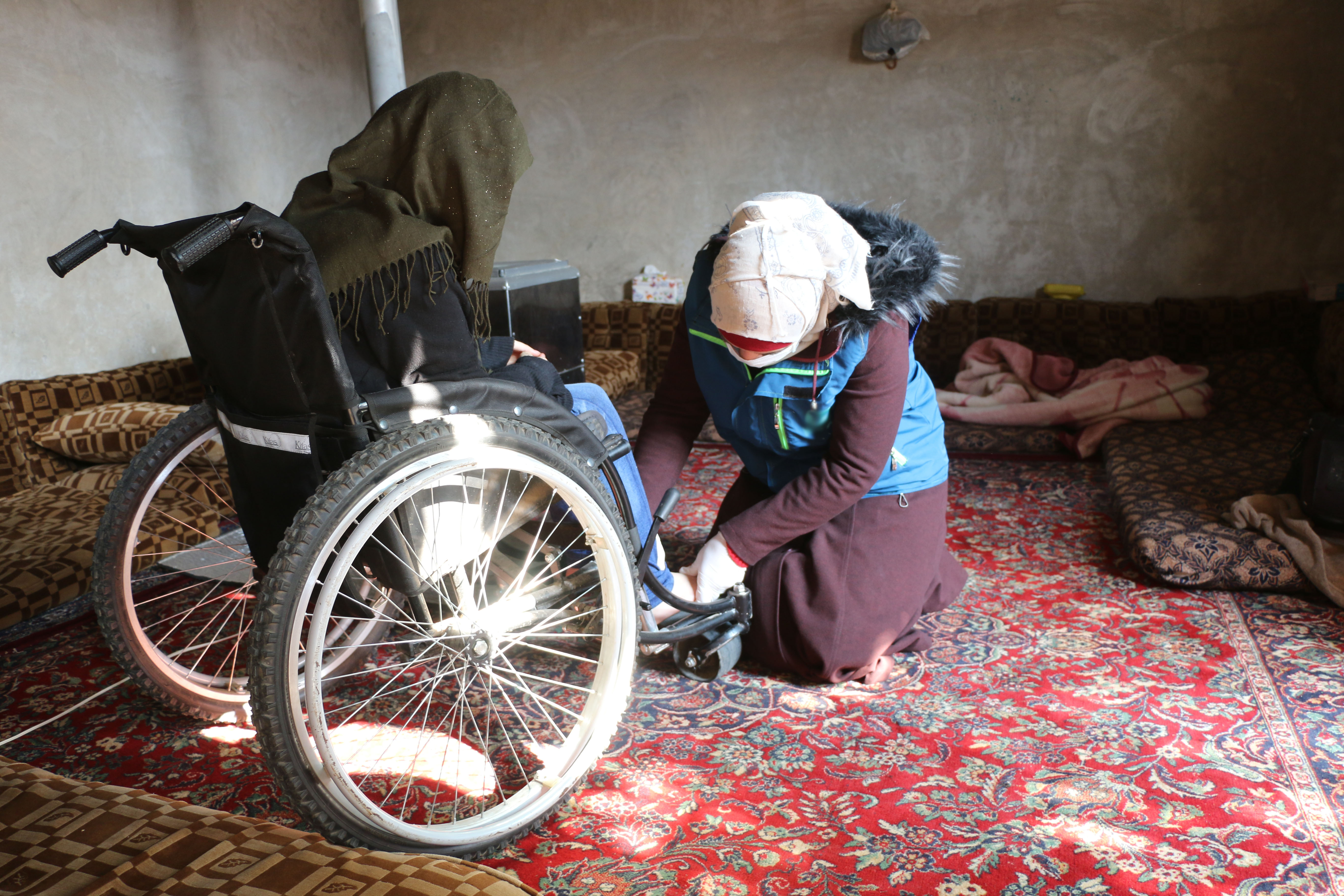 A woman with a disability received a wheelchair provided through funds from European Union Humanitarian Aid.
