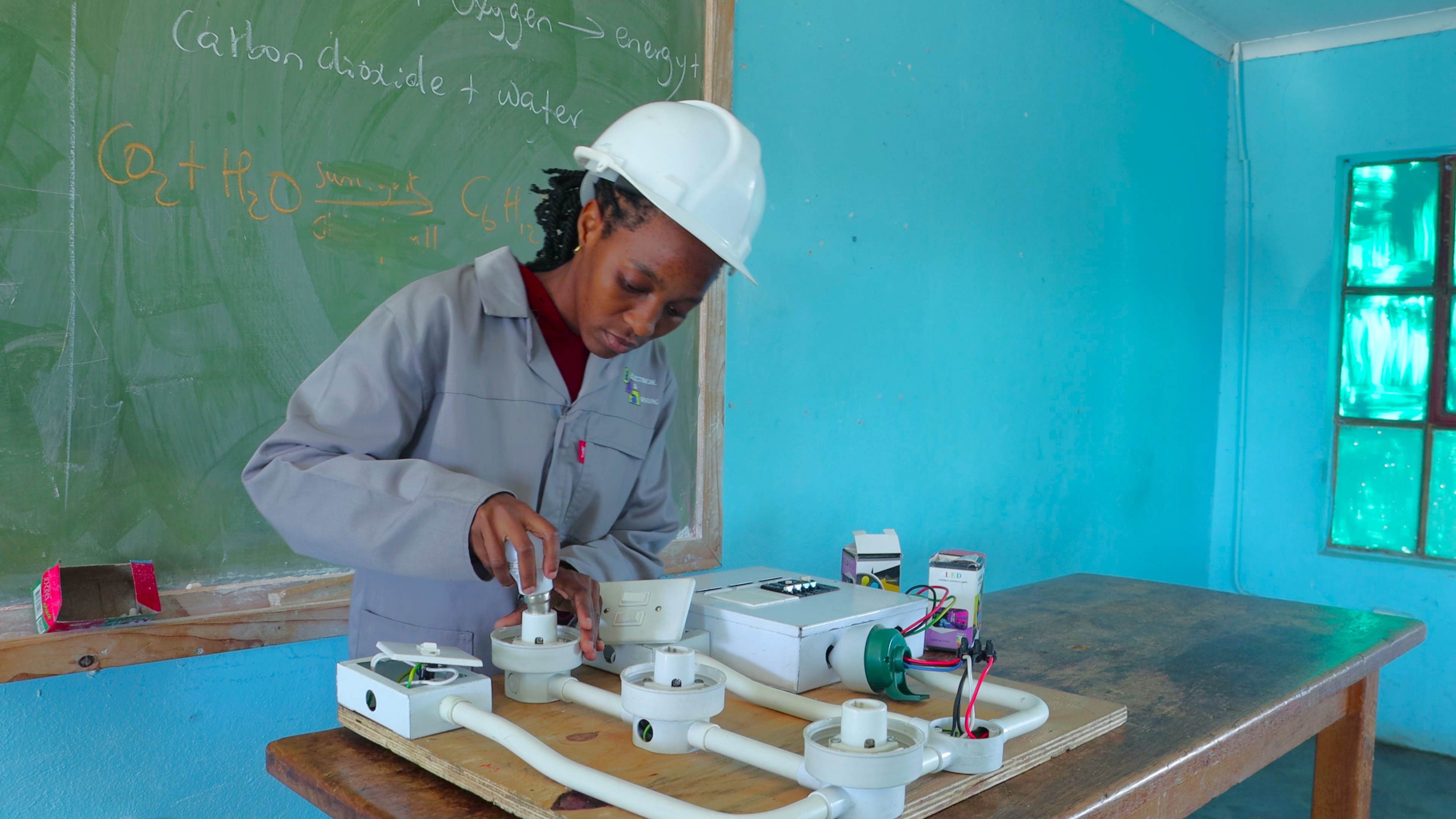 Nokwanda working on an electrical wiring model as part of her practical. 