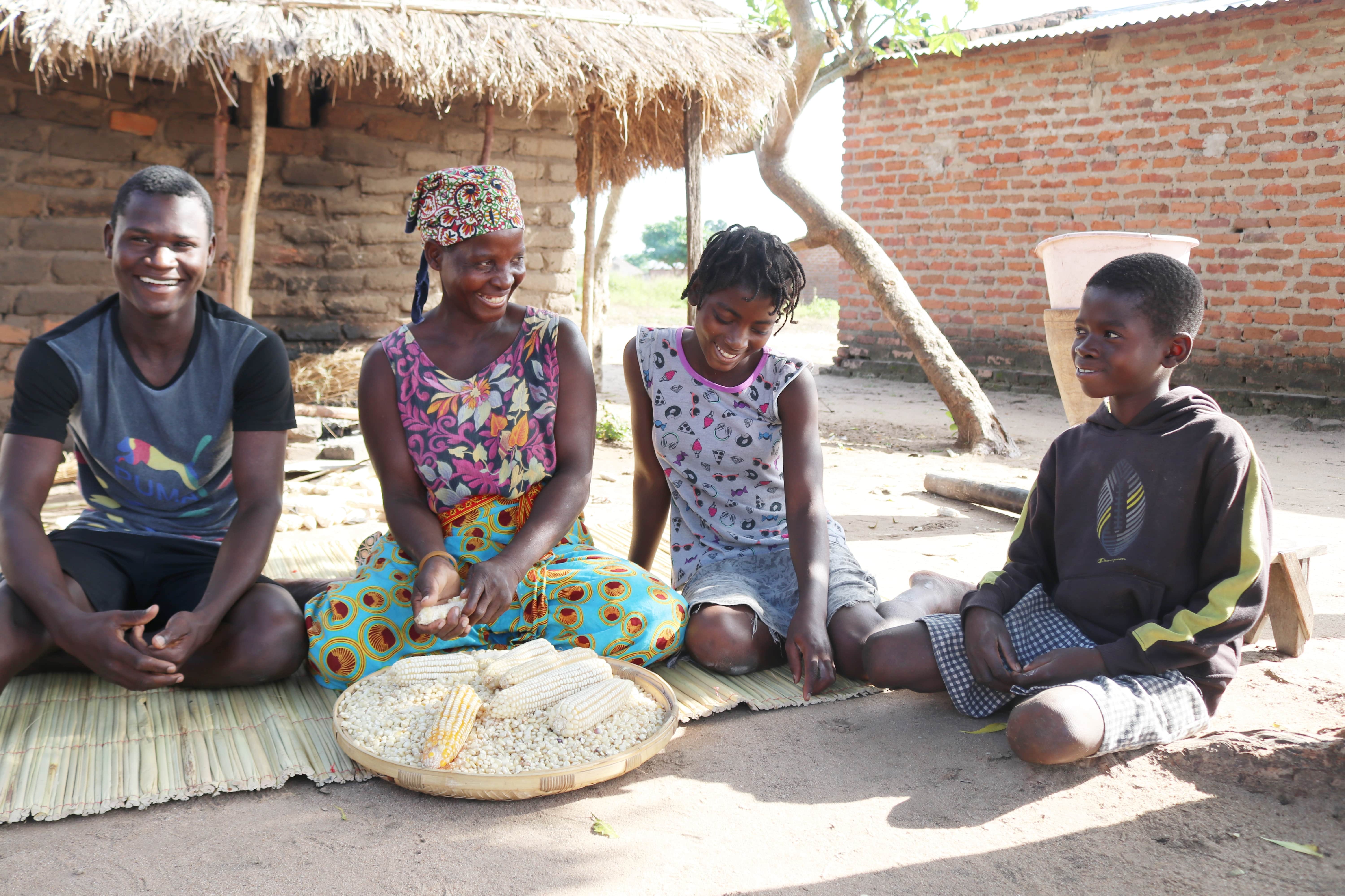 From left to right, Yona, Ofélia, Joana and António are threshing corn in front of their house 