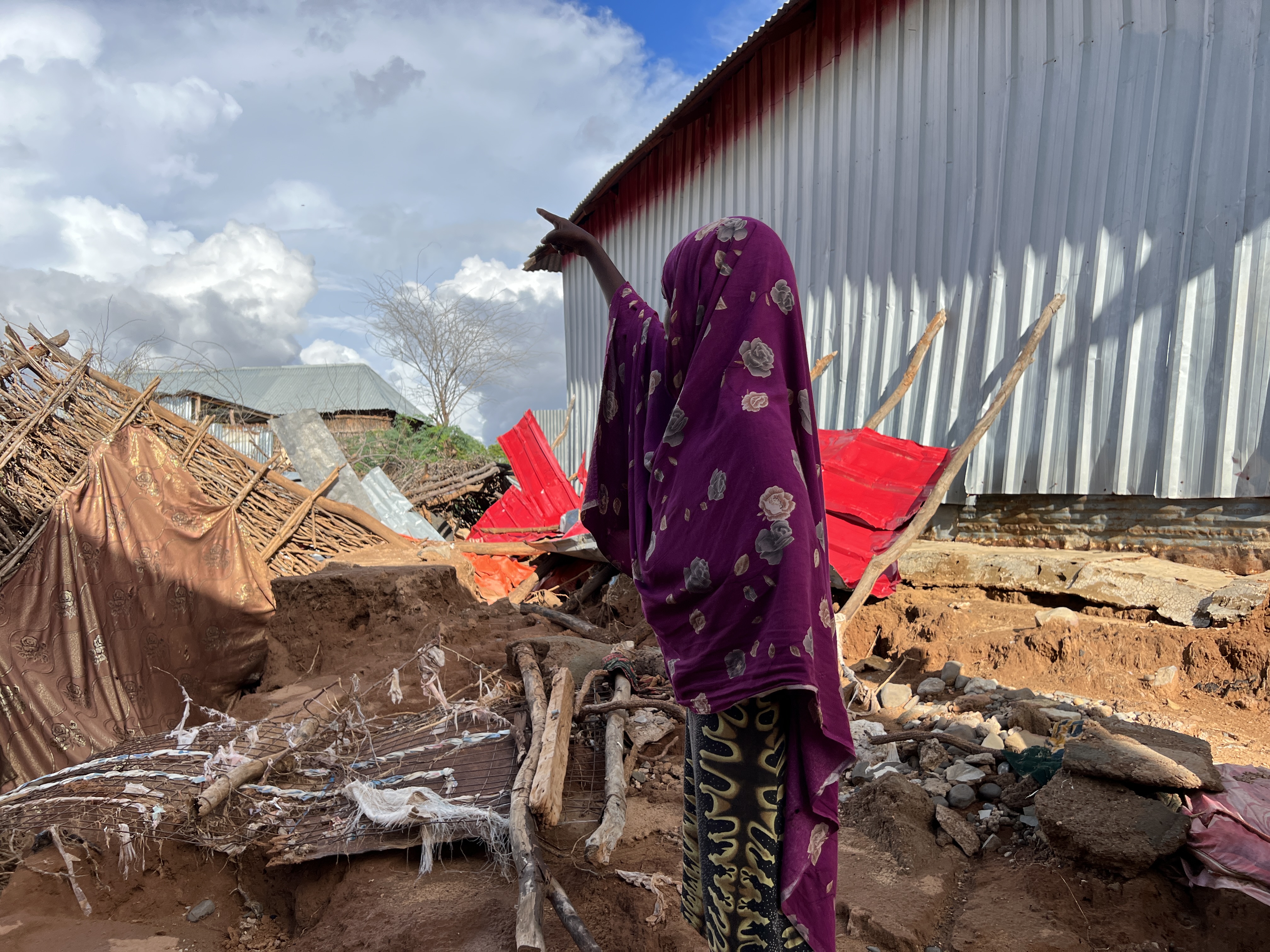 A girl in Luuq district points towards the direction of their house that was completely destroyed by the floods