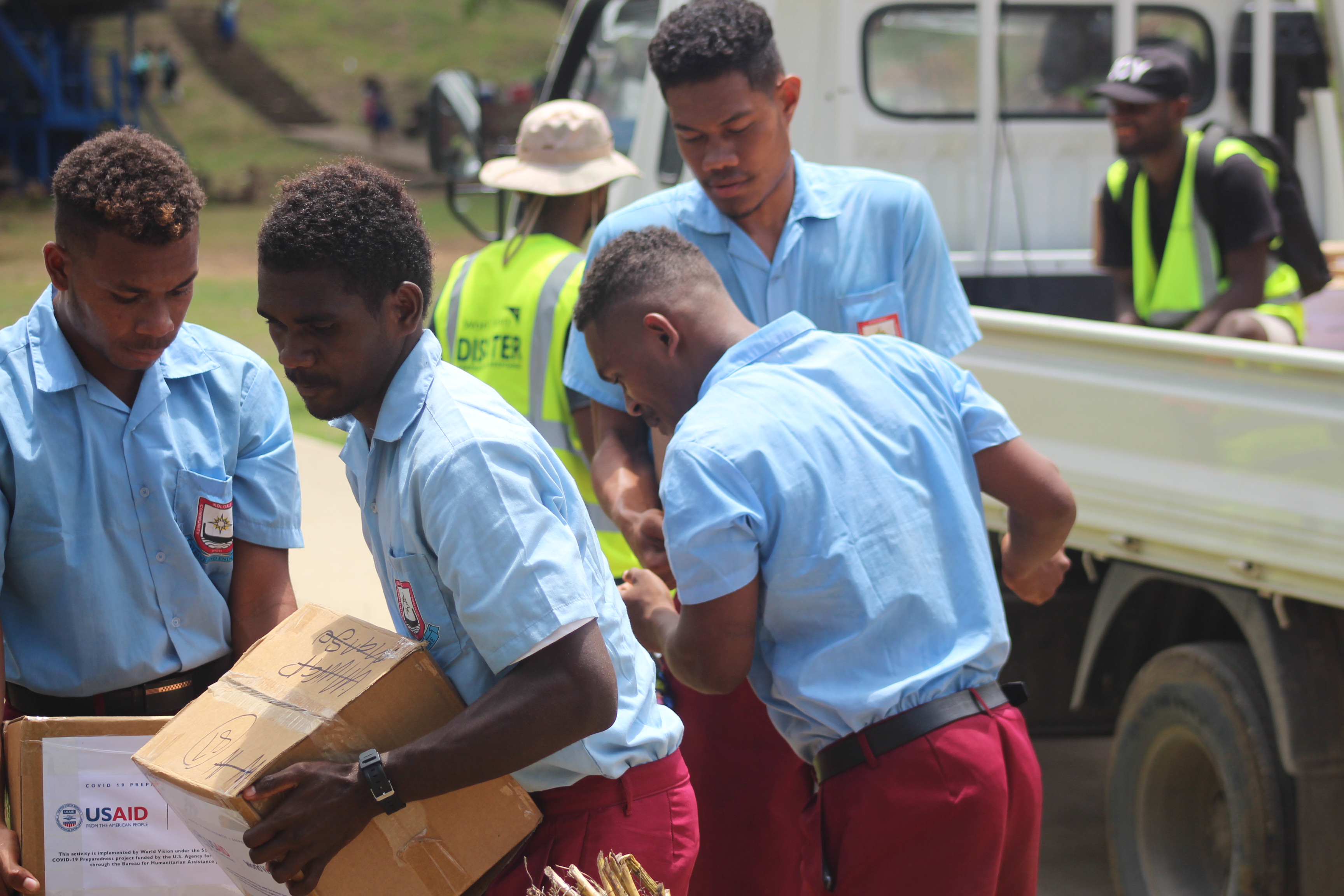 Koloale Community High School Students help to unload cartons of soaps from truck. 