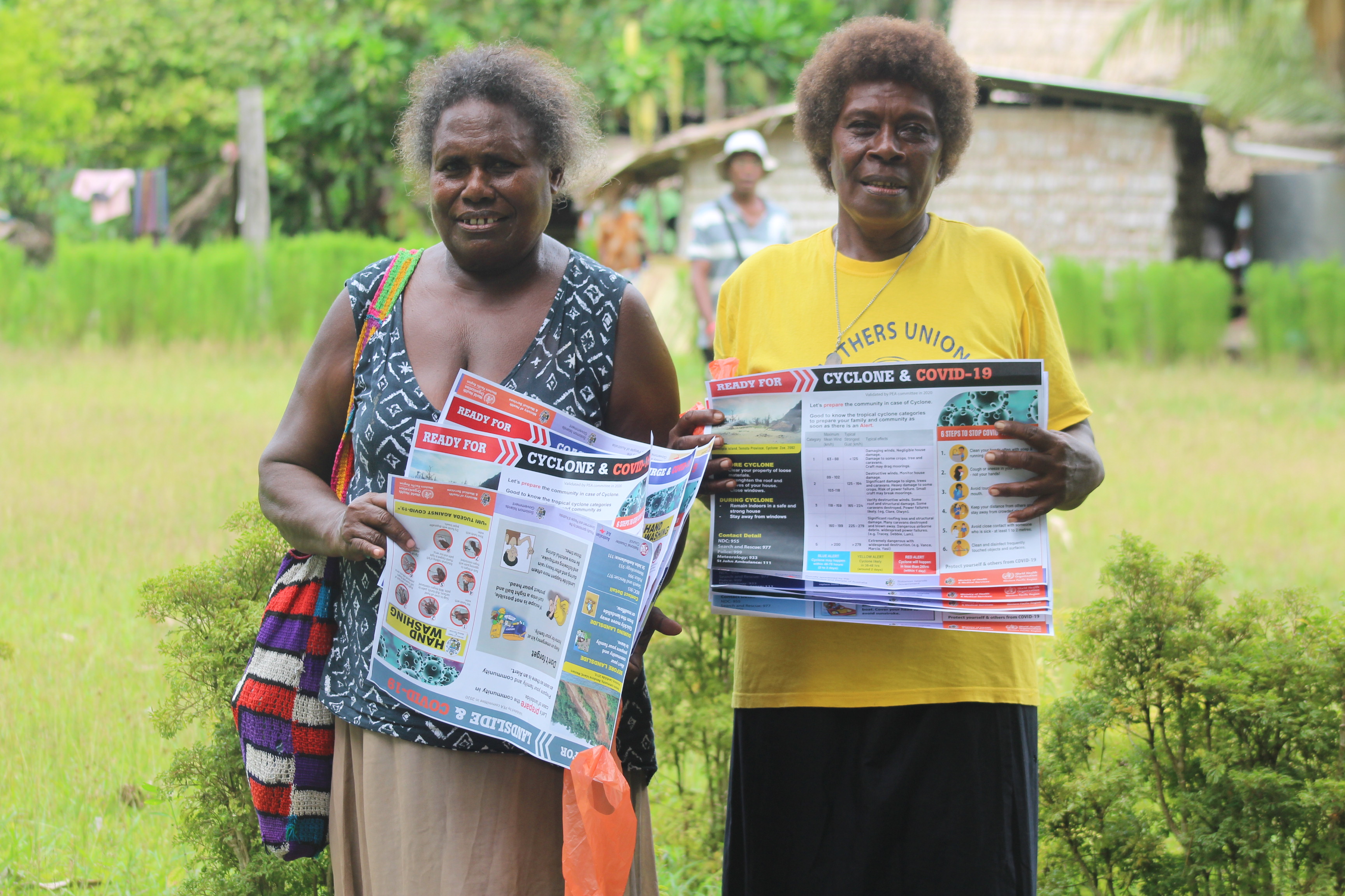 Dorothy and Rose showing the COVID 19 Materials received from World Vision