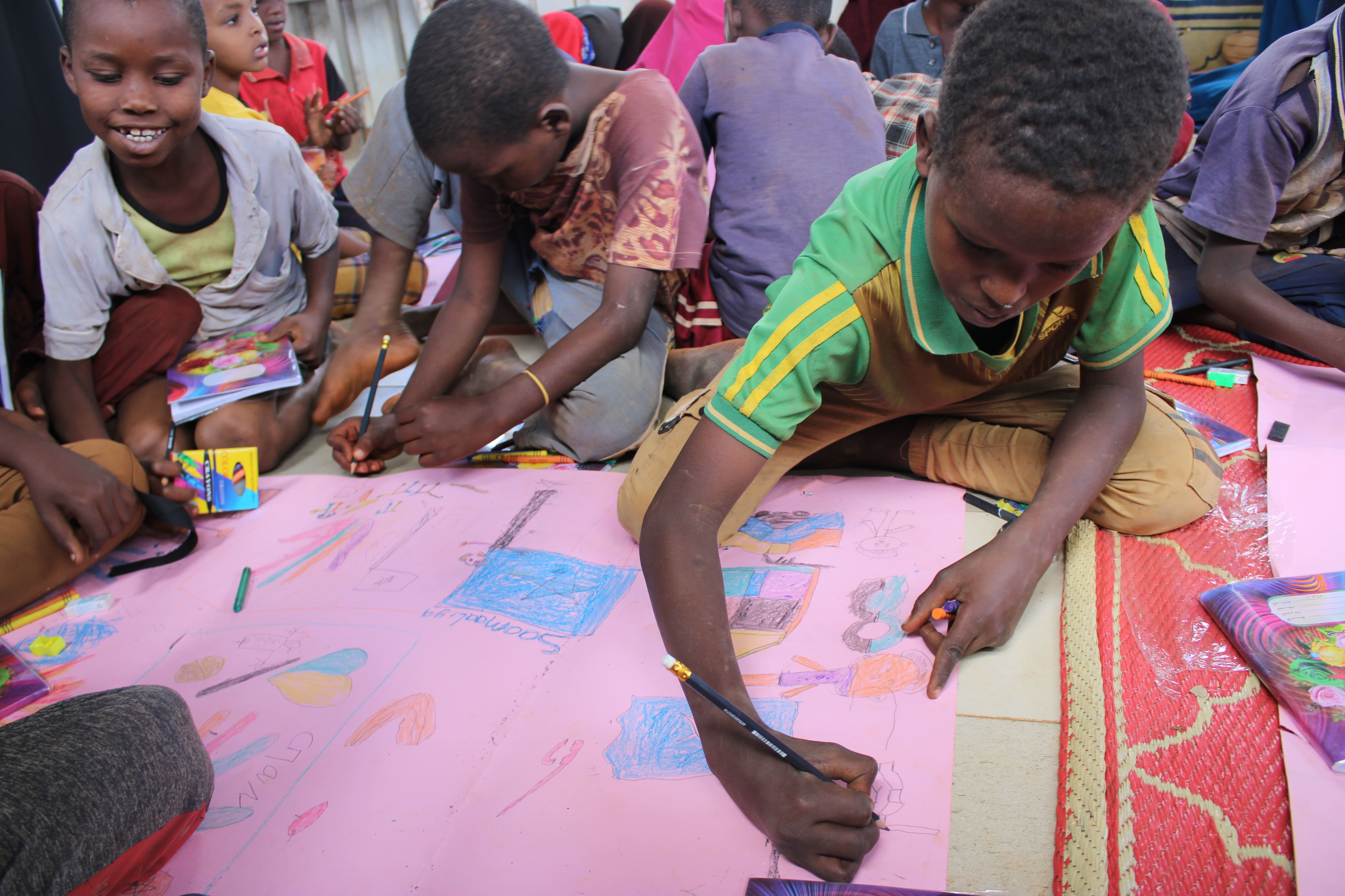 Issack (in green) pictured at a World Vision Child Friendly Space centre in south central Somalia.