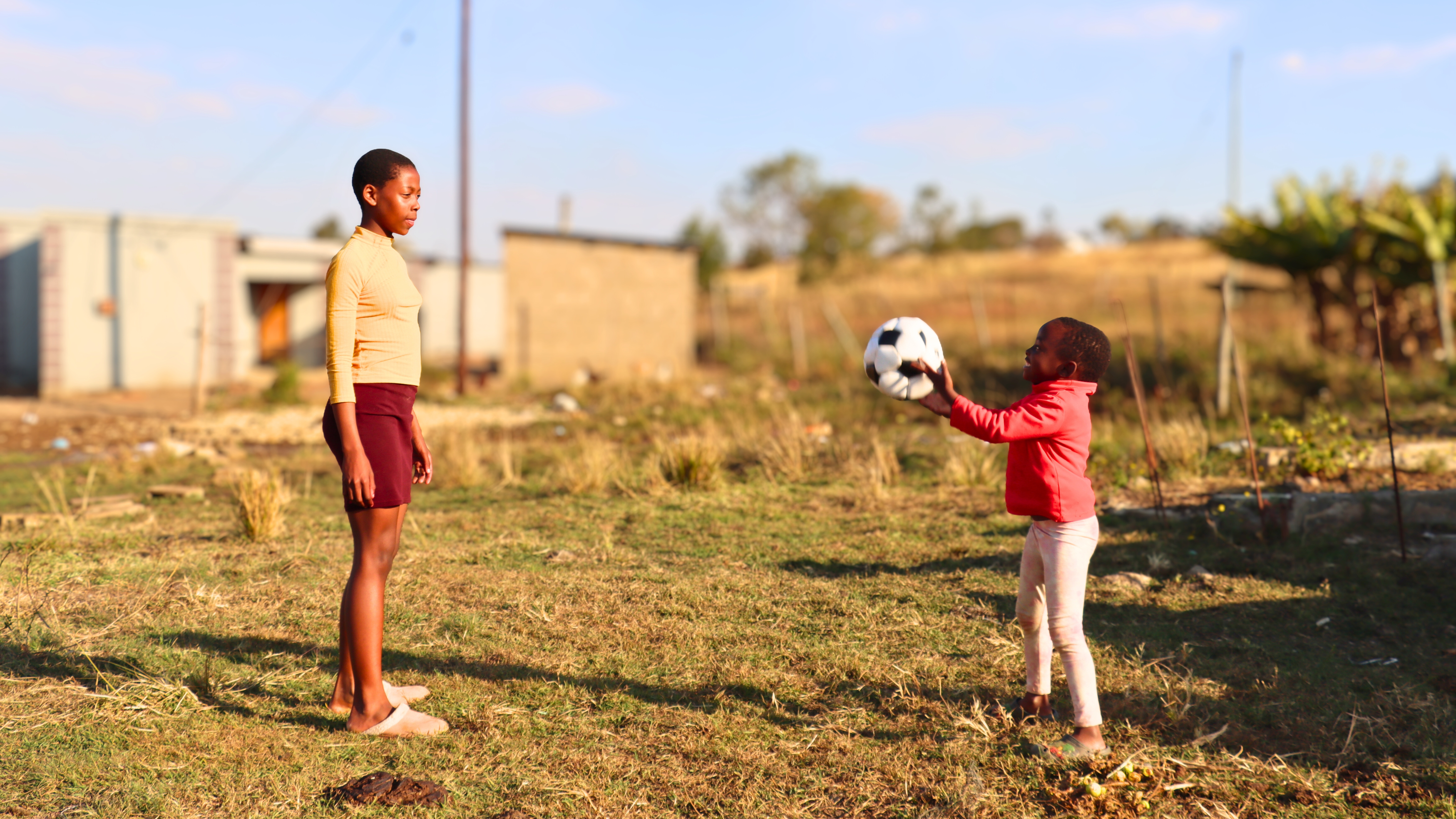 Hlelweyinkhosi playing with her niece Eyenkhosi. She had just helped her mother feed the family pigs in the piggery.