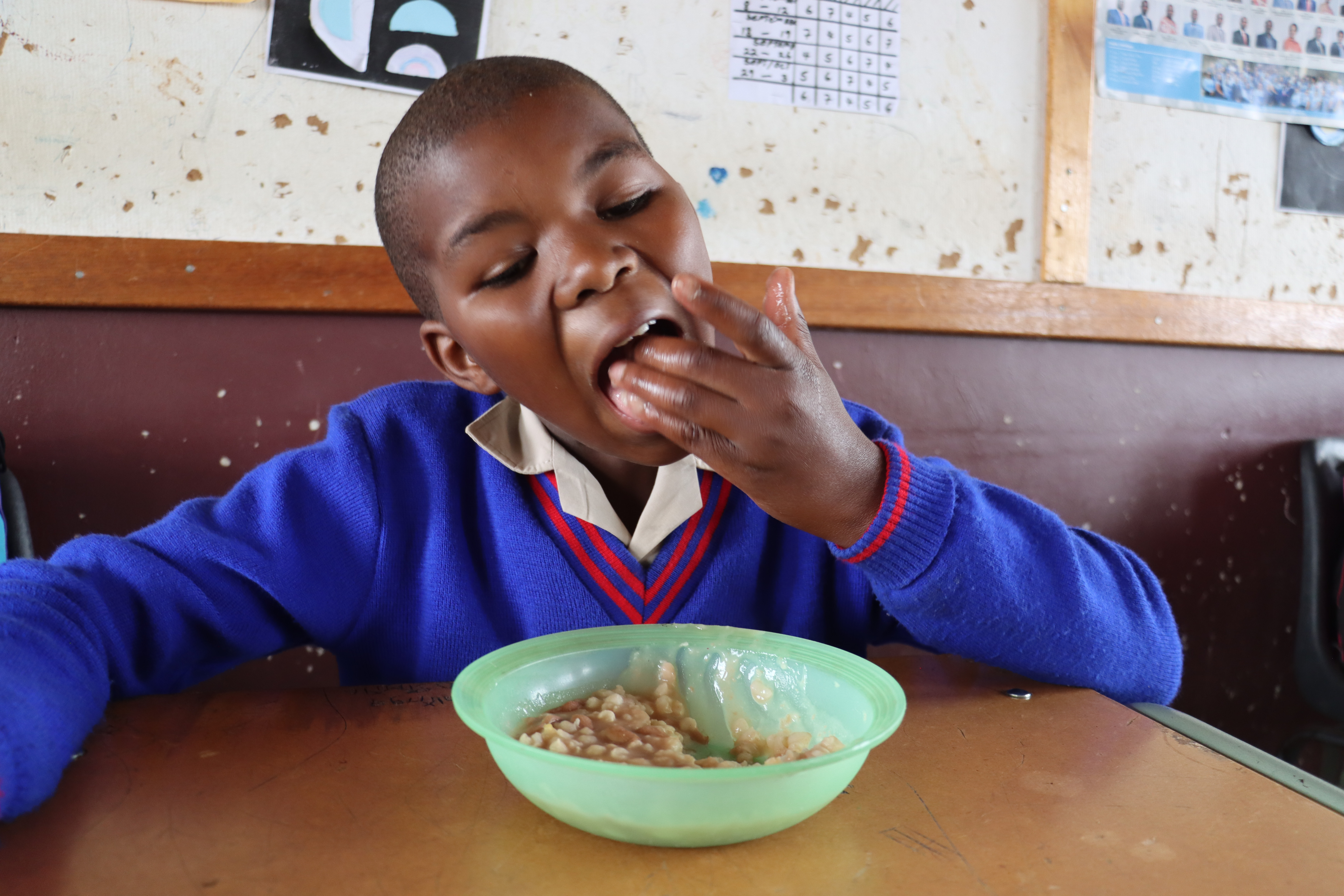 A learner enjoying lunch inside a classroom.