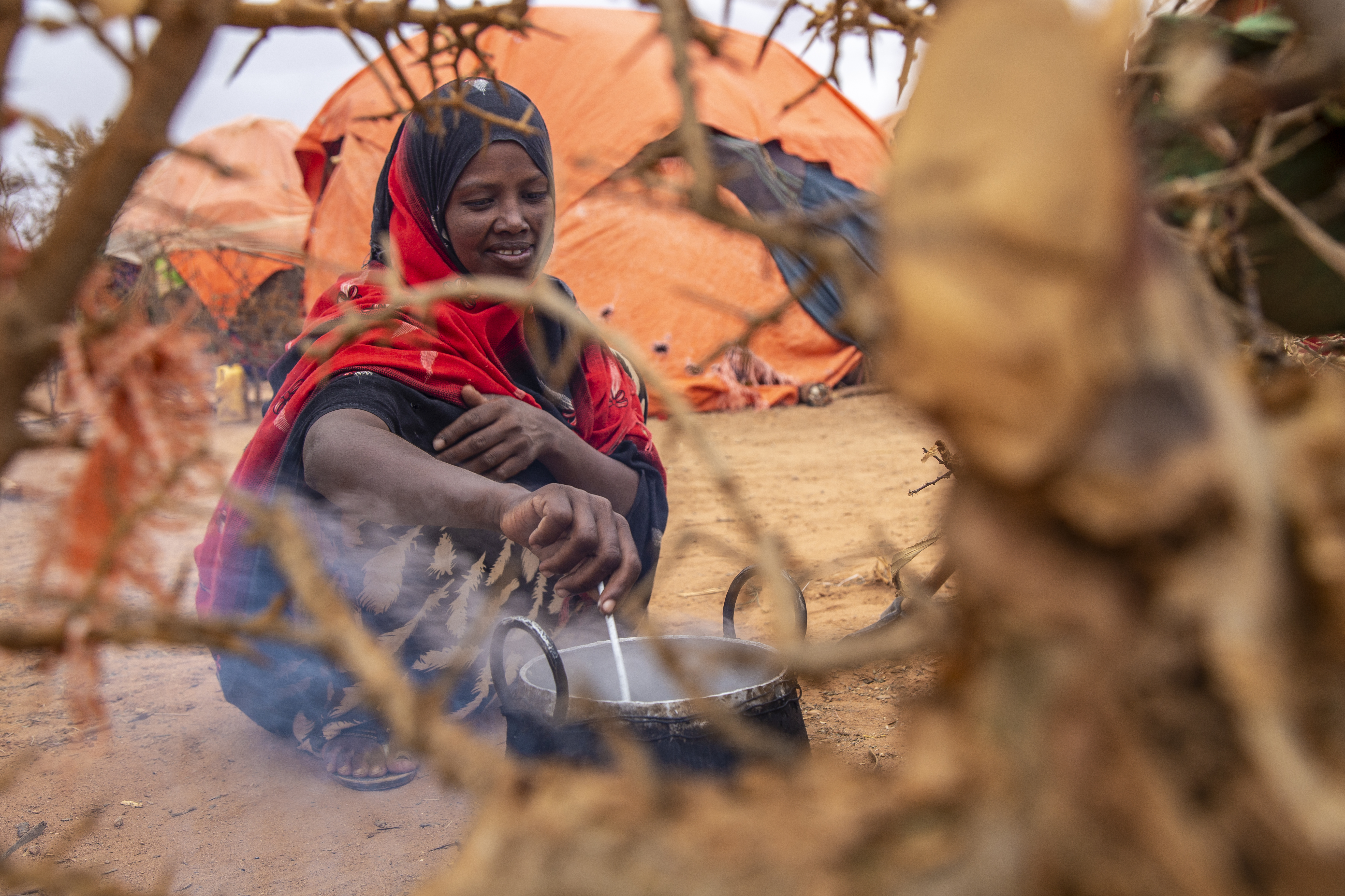 Displaced by the drought. Pictured, a 22-year-old woman prepares a meal in the open air