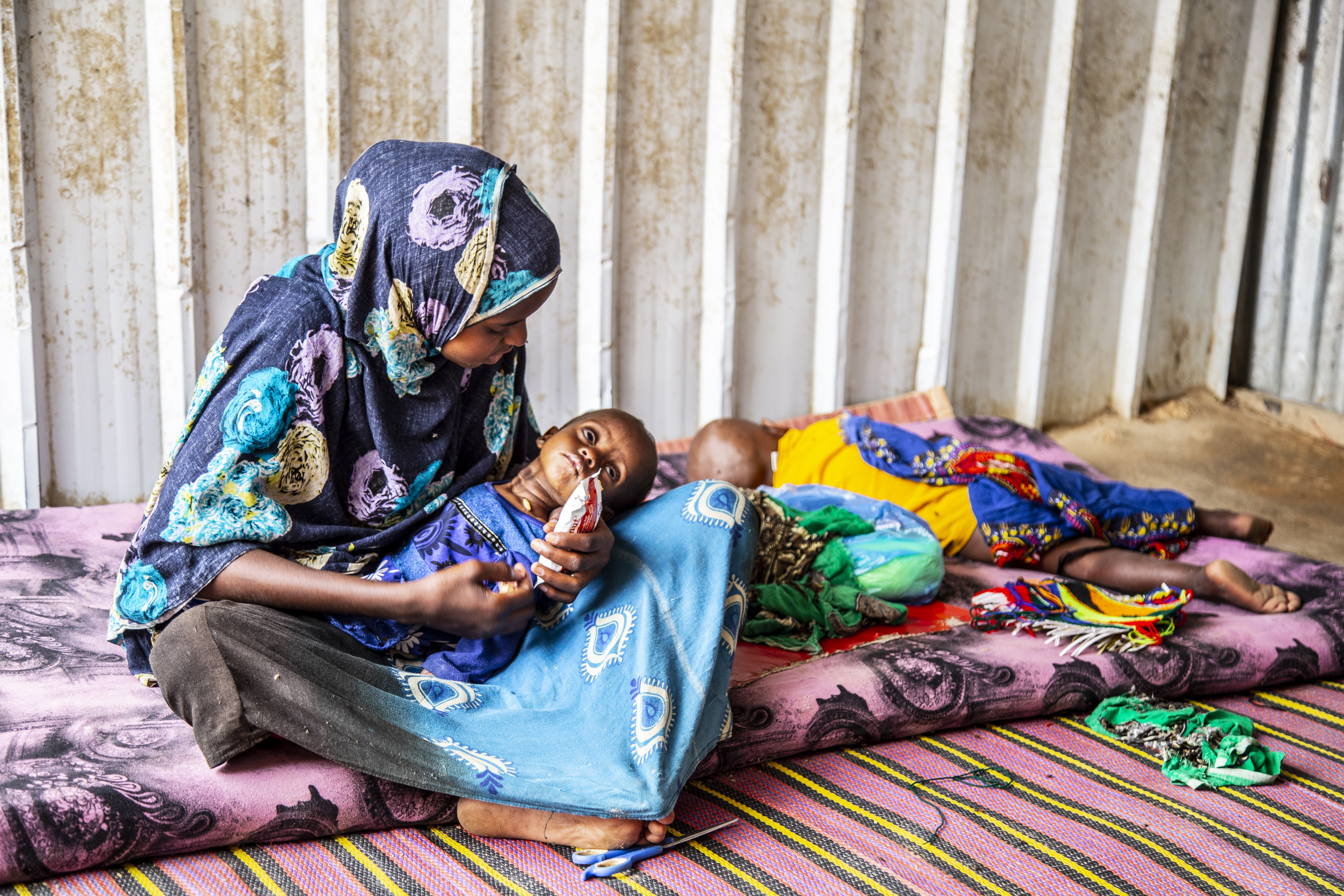 14 year-old Rahima looks after her seven-months old sister, Hamdi while her mother went to fend for food for the family. 