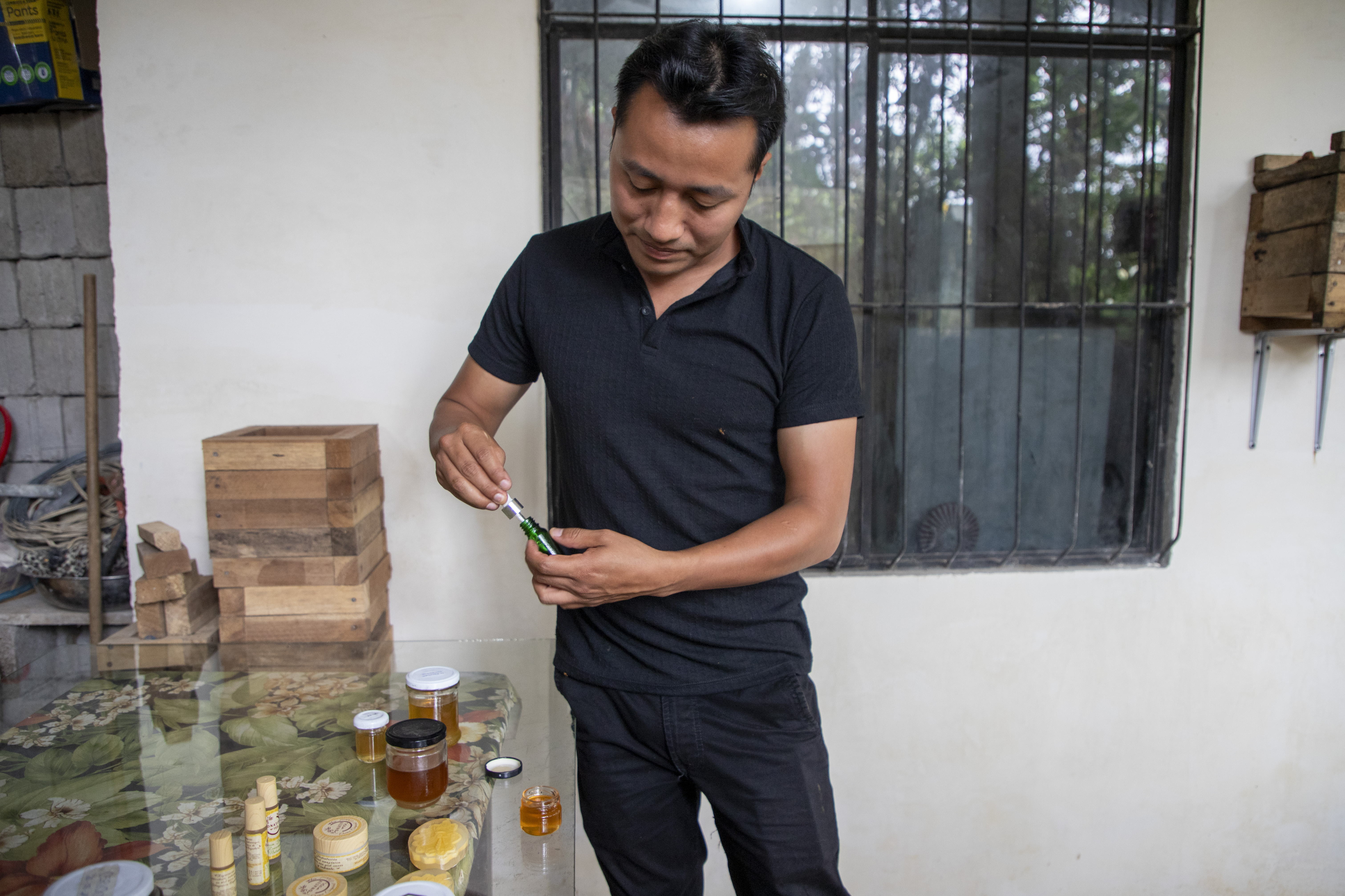 Jefferson proudly shows the range of products he’s made using honey he’s collected, blending tradition with creativity./ Ecuador/2025.