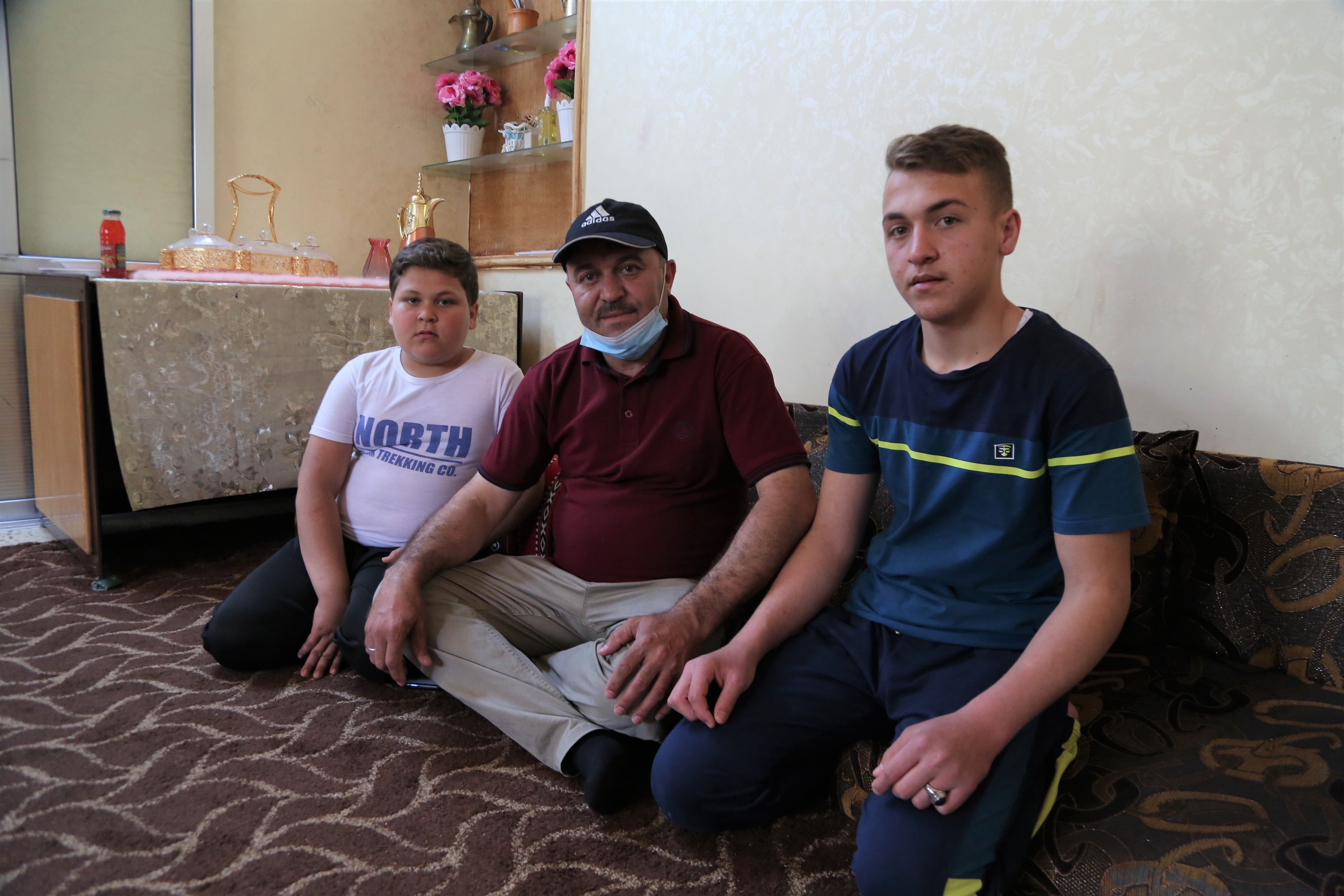 Mohammed, 49, sitting with his two sons: Mahmoud and Mohammed.