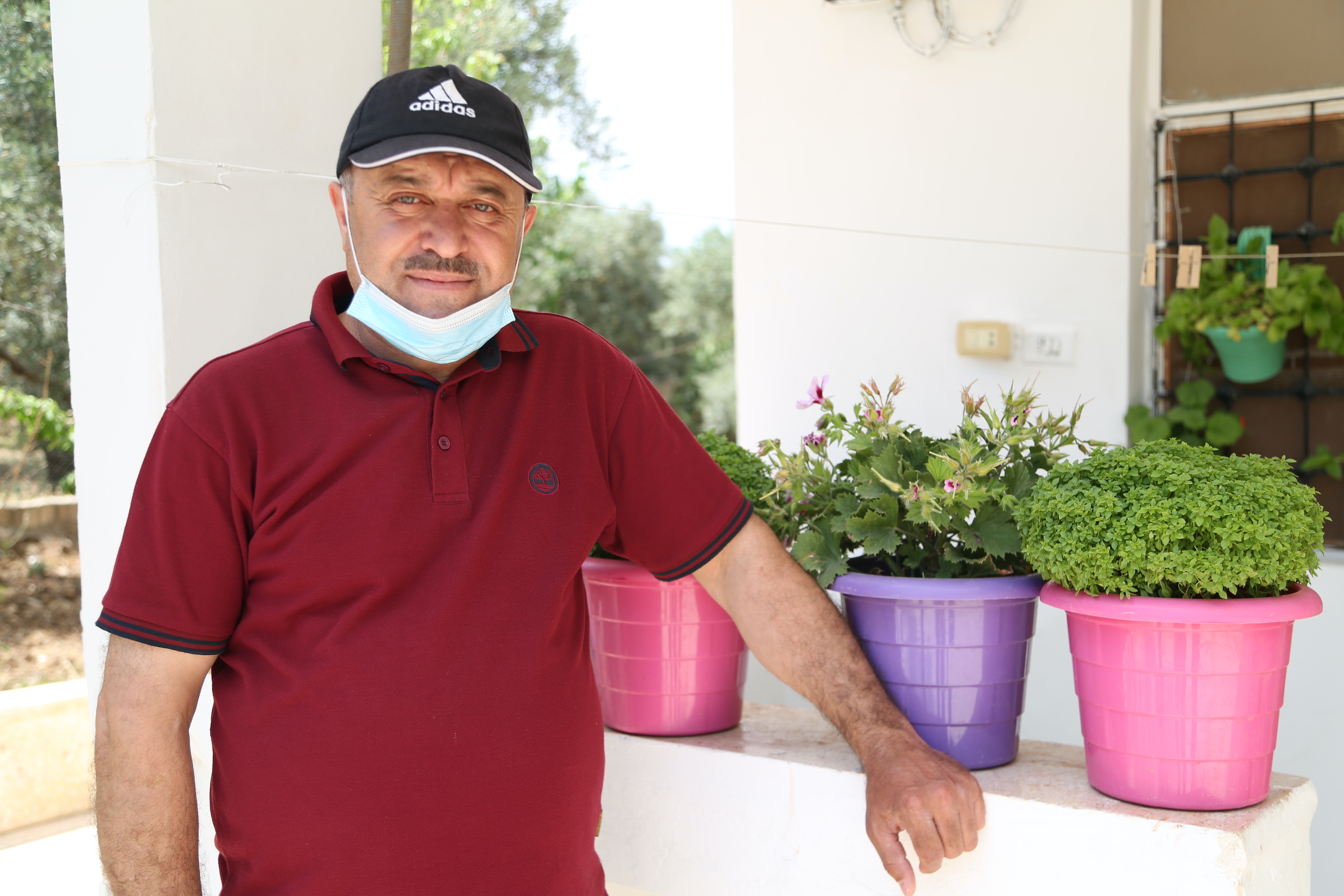Mohammed, 49, standing in his house's porch