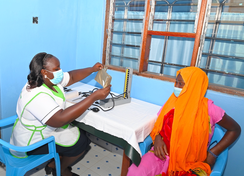 Nurse Fridah getting ready to check the blood pressure of a pregnant woman at Midoina Health Dispensary in Kilifi County, Kenya.
