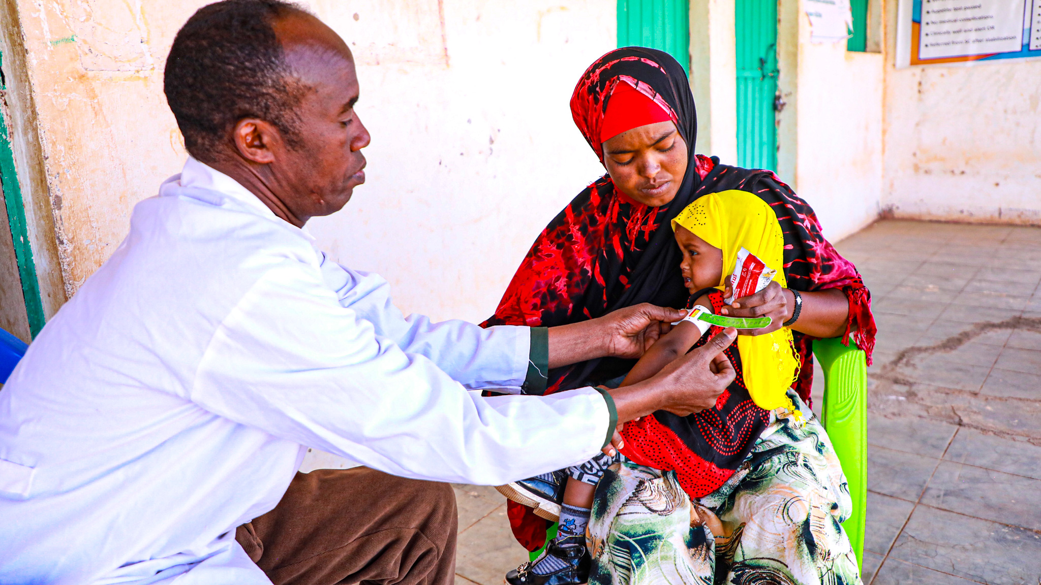 Abdi measuring Sefa's nutritional status