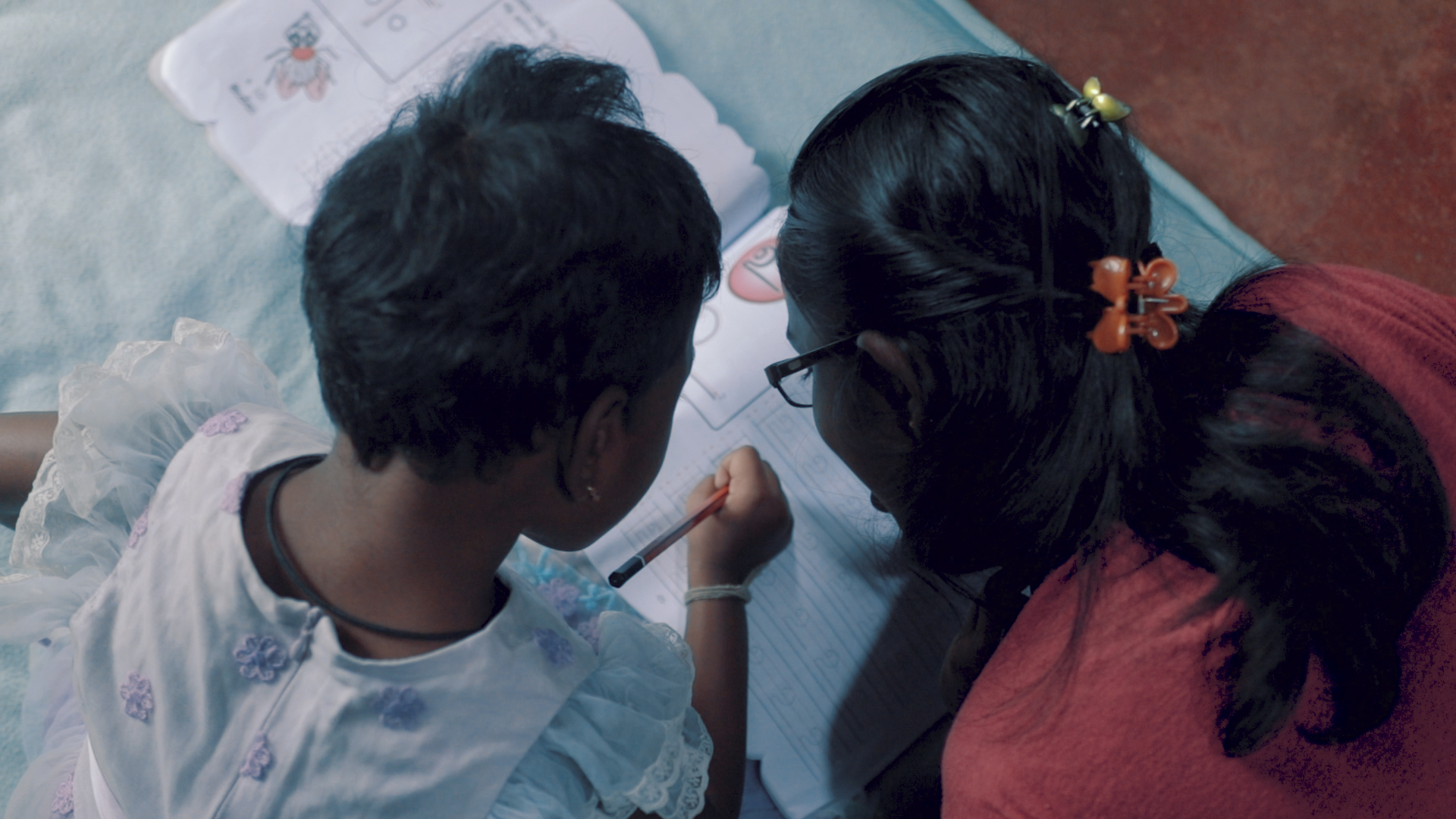 Maduwarshini learning to scribble with her sister