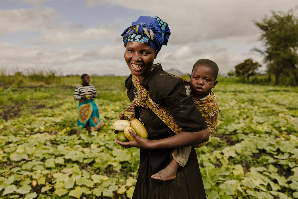 a mother carrying her child on her back