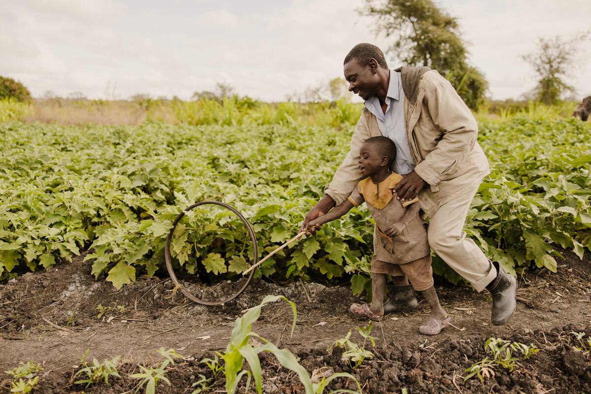 Father plays with his son and a wheel in Malawi