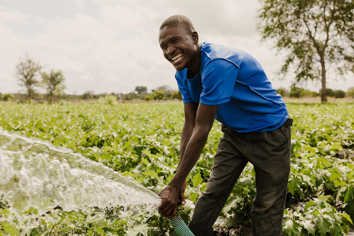 a farmer watering his plants in Malawi