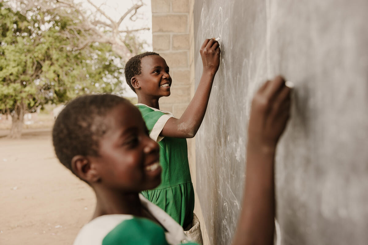 Children writing on a chalk board