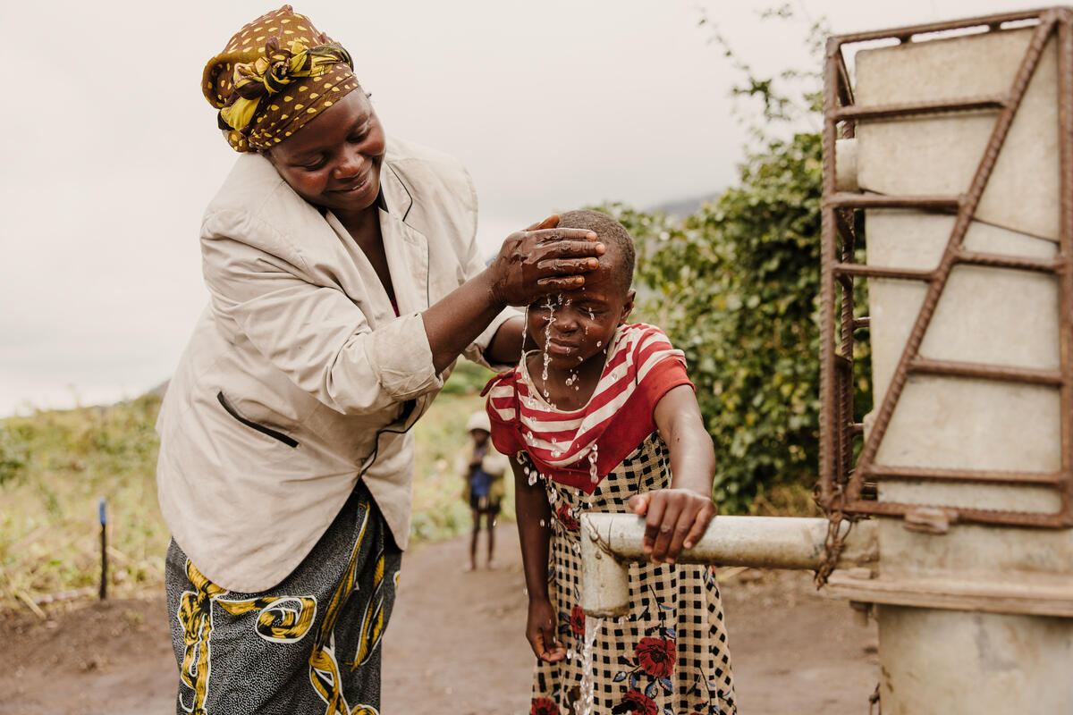 A mother washing her child with water