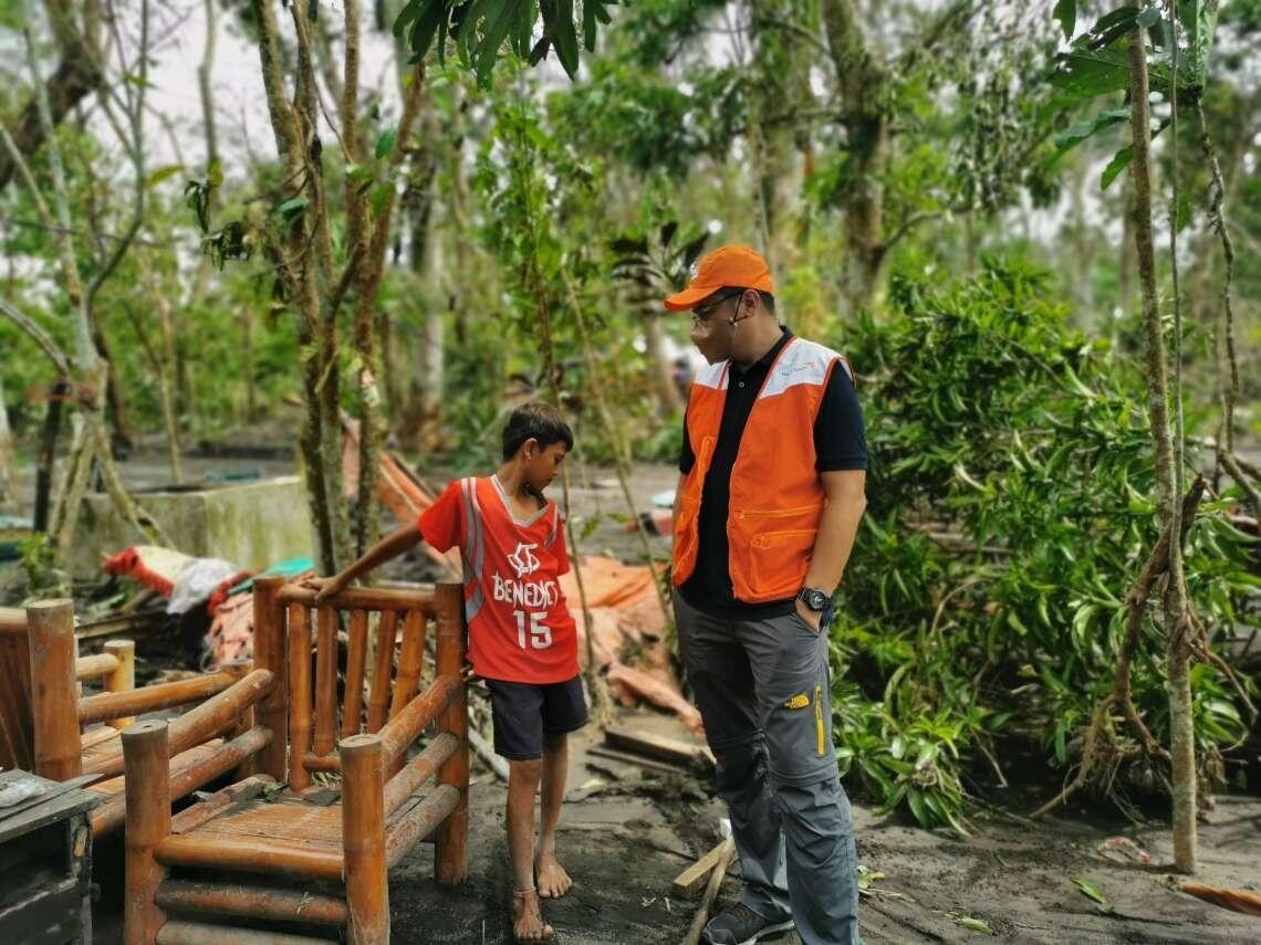 Mico speaks to a member of World Vision Philippines' disaster response team.