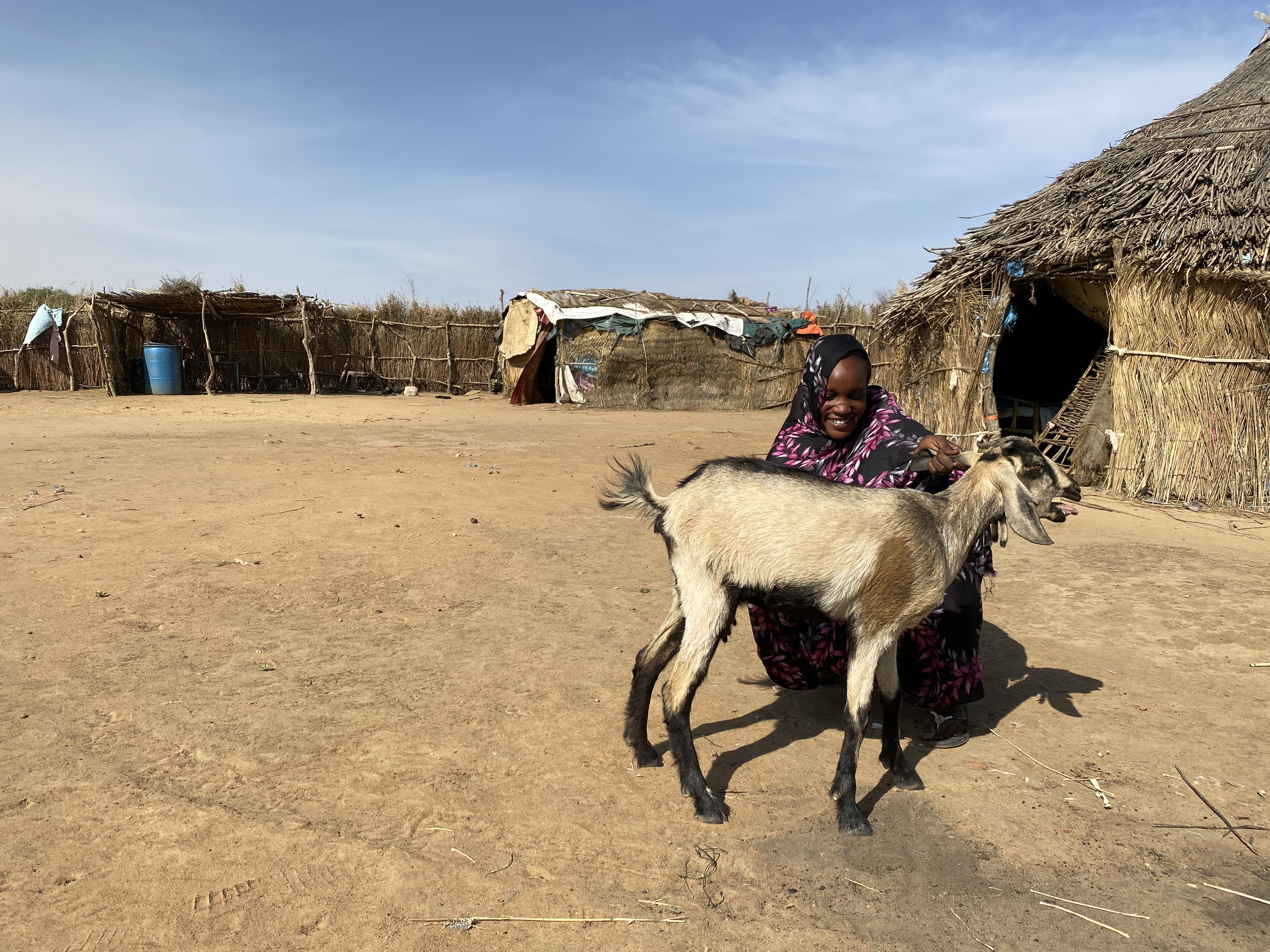 Woman holding goat she bought with funds from World Vision Sudan