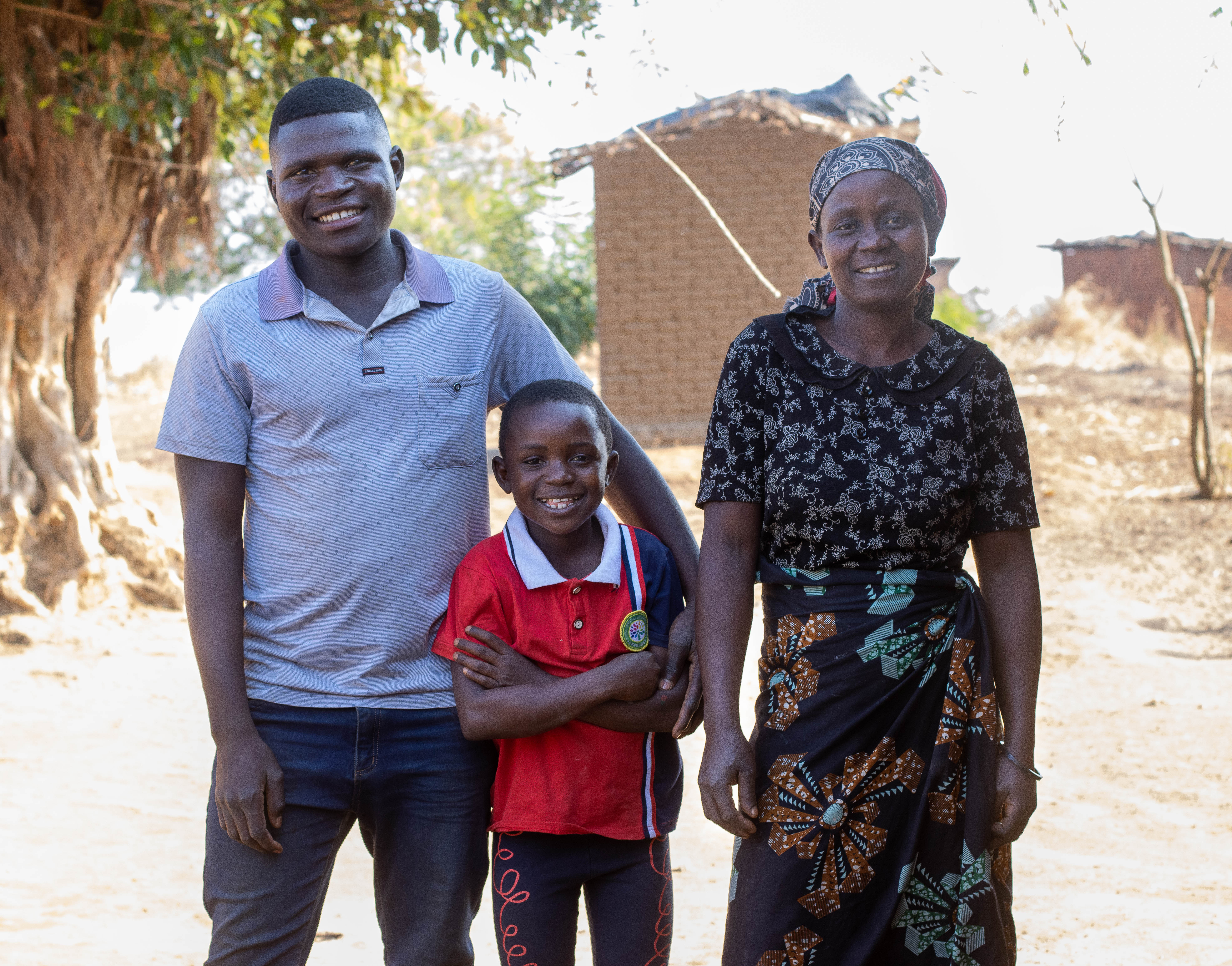 Milca wearing a  black dress, her daughter, Doreen in the middle and her husband Foster