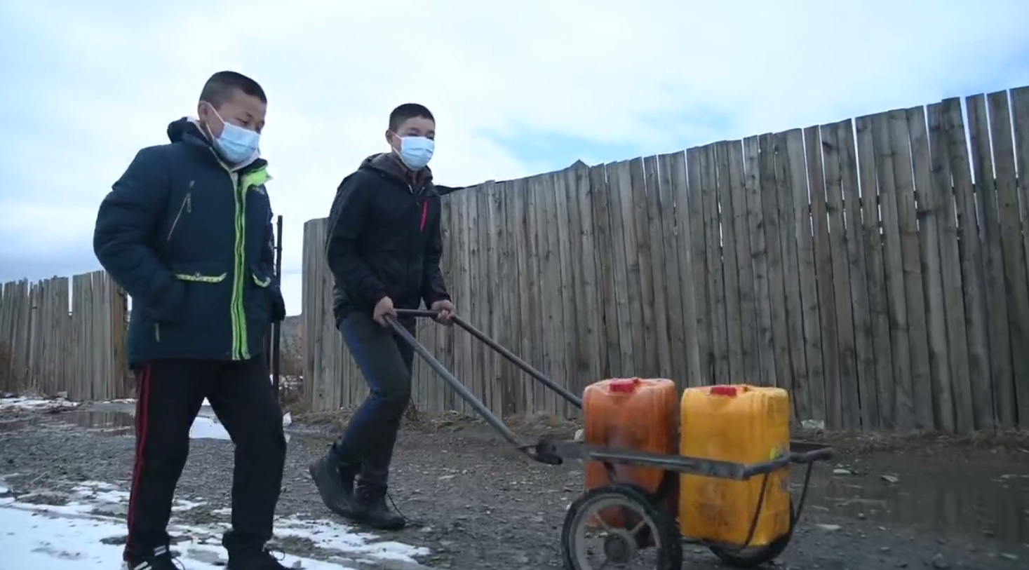 Two Mongolia boys transporting water