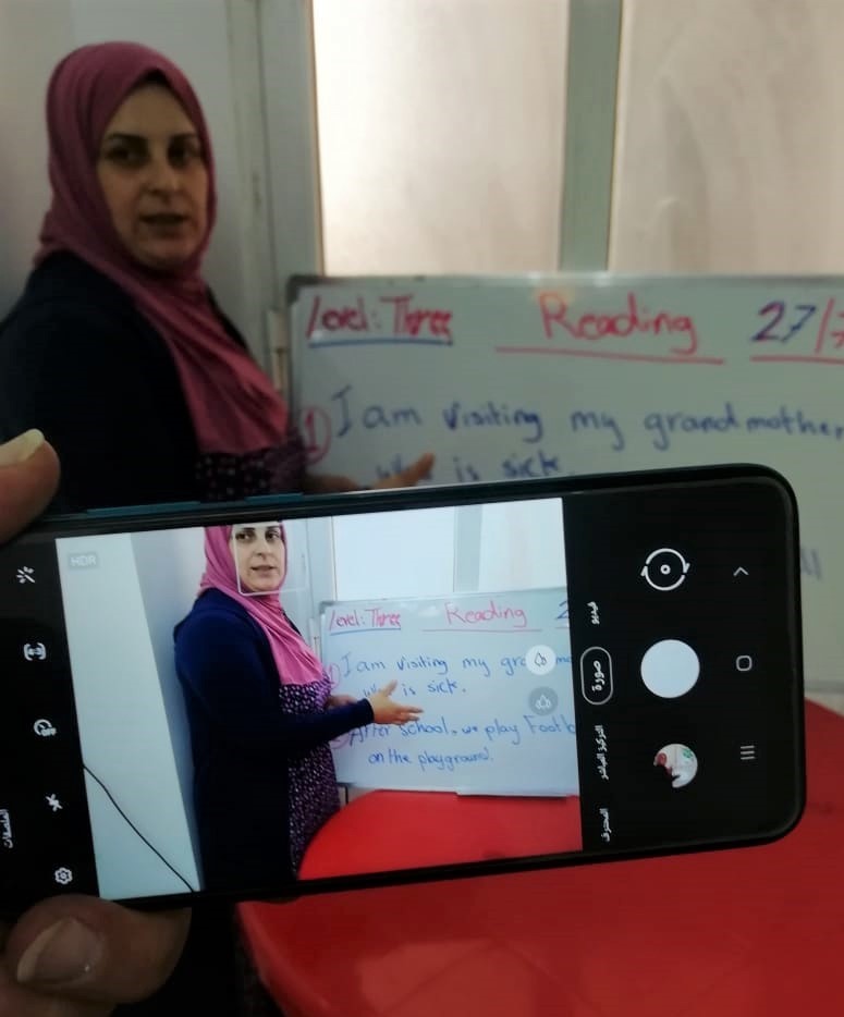 Nahed, remedial class teacher, explains a lesson on camera so as to send the video later to her students