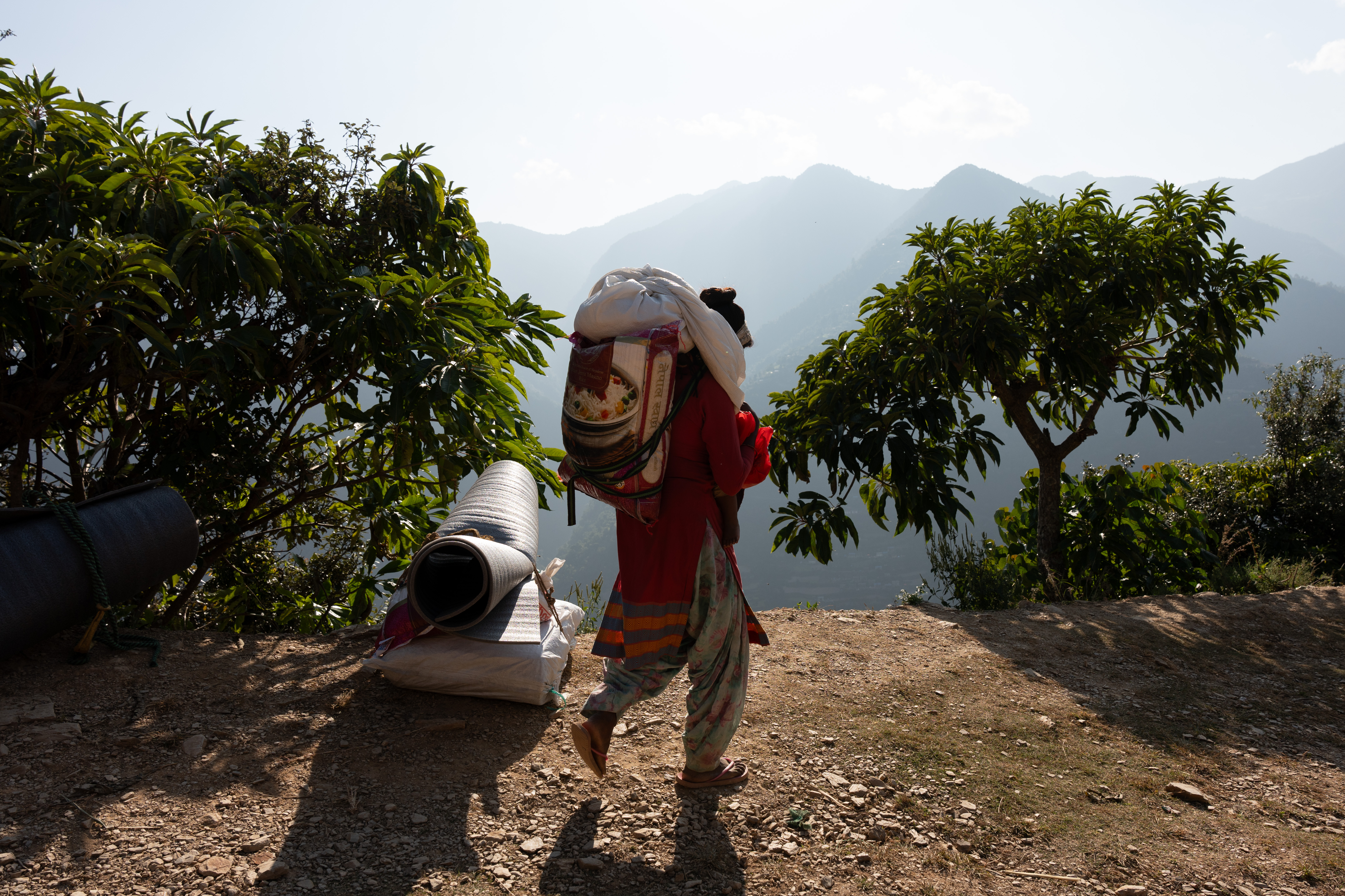 Kalawati heads home with a sack of rice and her nine month old after receiving relief items.