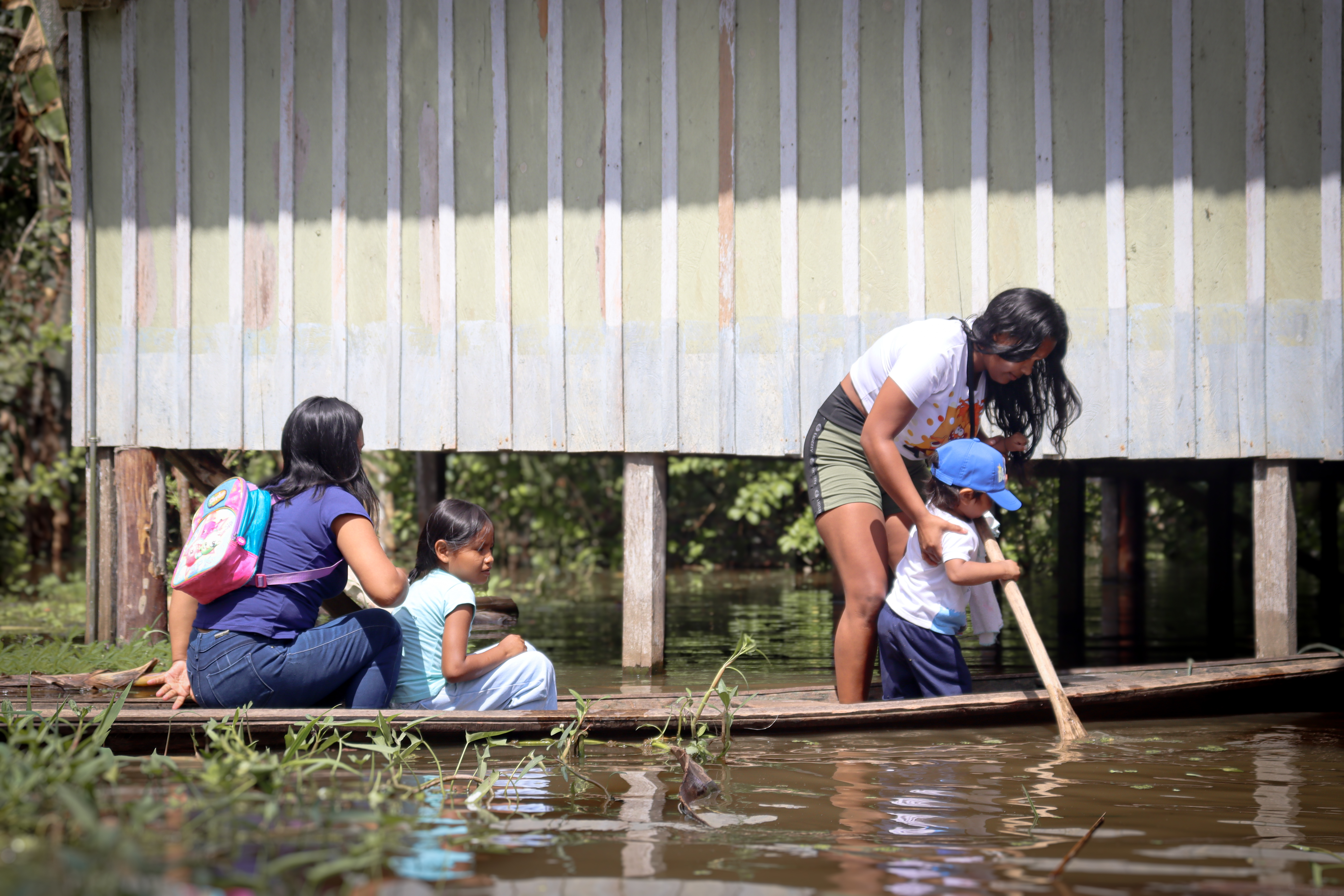 A family navigates floodwaters in the Colombian Amazon, making their way to shelter after heavy rains