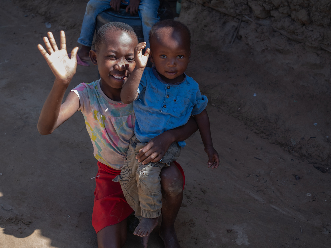 Kevin and his sister Husna outside their home ready to play after Kevin has just been fed by their mother. © World Vision Photo/Peter Mwaura