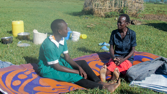 Mitchell and her mother chat as they recall and narrate the condition that the floods had put them in a few months ago. They are seated on carpets that were donated by World Vision in partnership with the county government of Kisumu during disaster and emergency response. ©World Vision Photo/Peter Mwaura