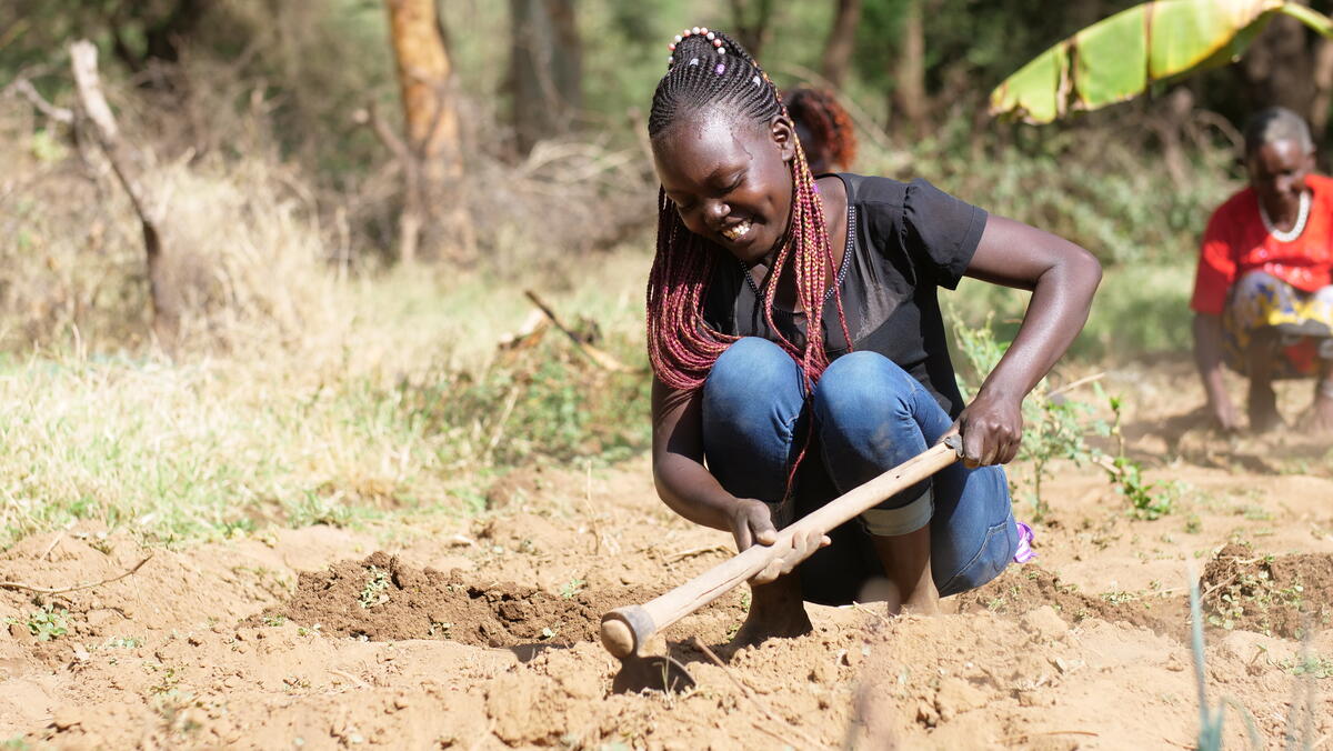 young kenyan girl works in the garden to regenerate forests and fight climate change