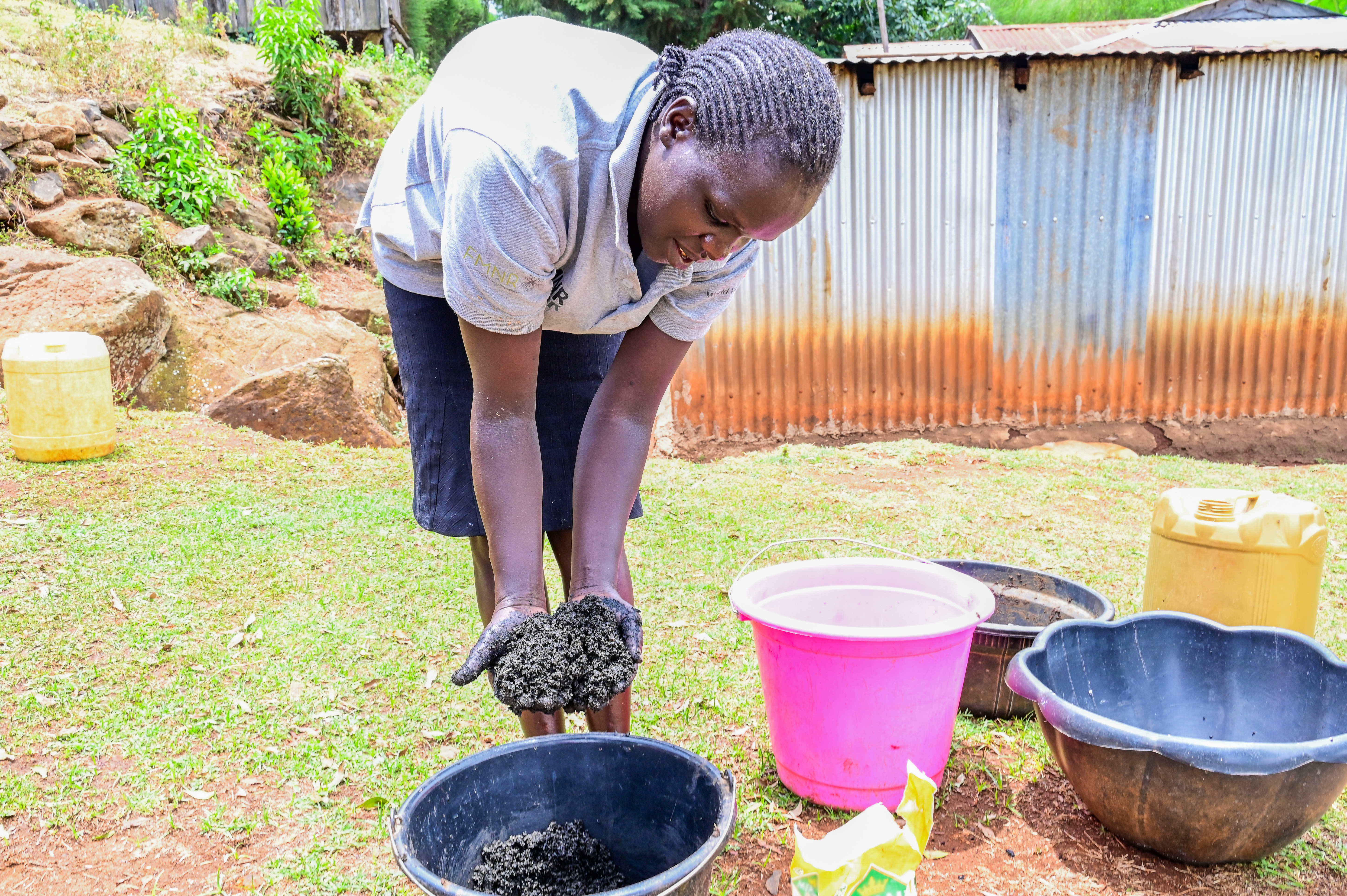 Sophia prepares a mixture of ash and cow dung which will be used to make briquettes.  ©World Vision Photo/ Hellen Owuor