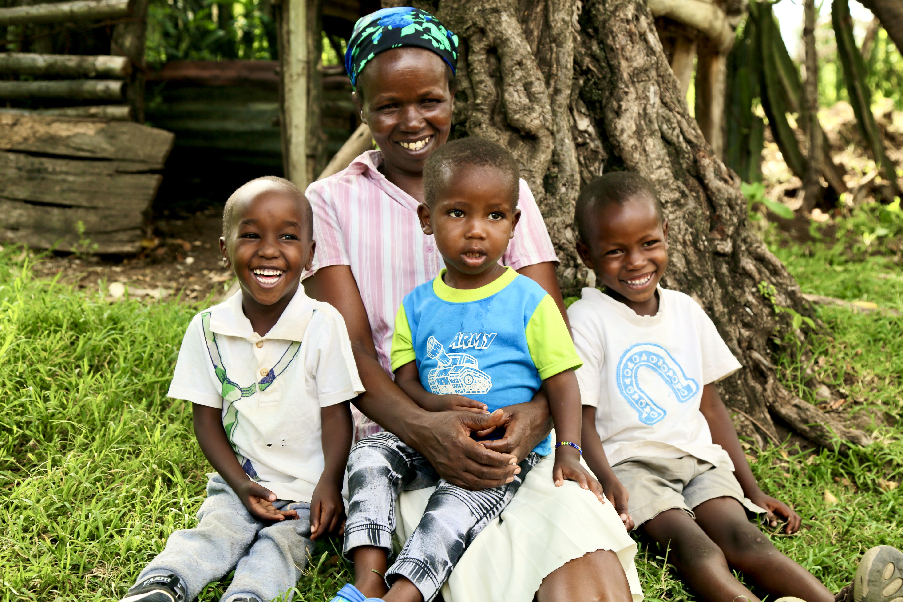 Lily, a mother of 11, sits with her three young children after enjoying a glass of clean drinking water in Bandaptai, Bomet County, made possible through a partnership between World Vision Kenya and P&G.