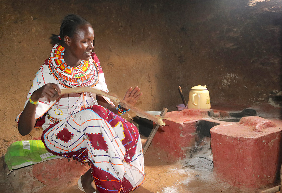 Petrolina lights fire on her newly installed improved cookstove. ©World Vision Photo/Wesley Koskei.