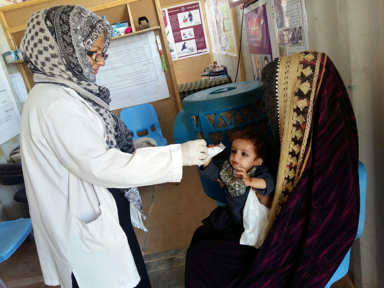 The nurse is checking malnourished child.